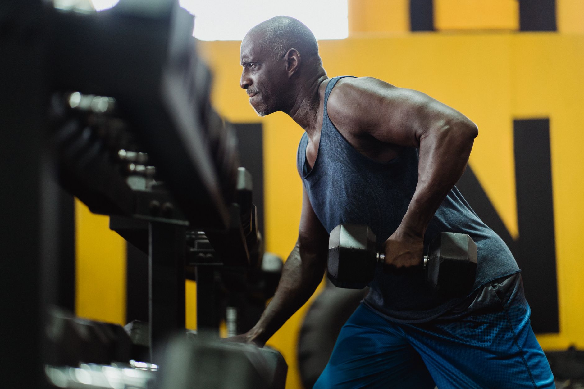 Athlete lifting dumbbells in gym, showcasing strength and determination.