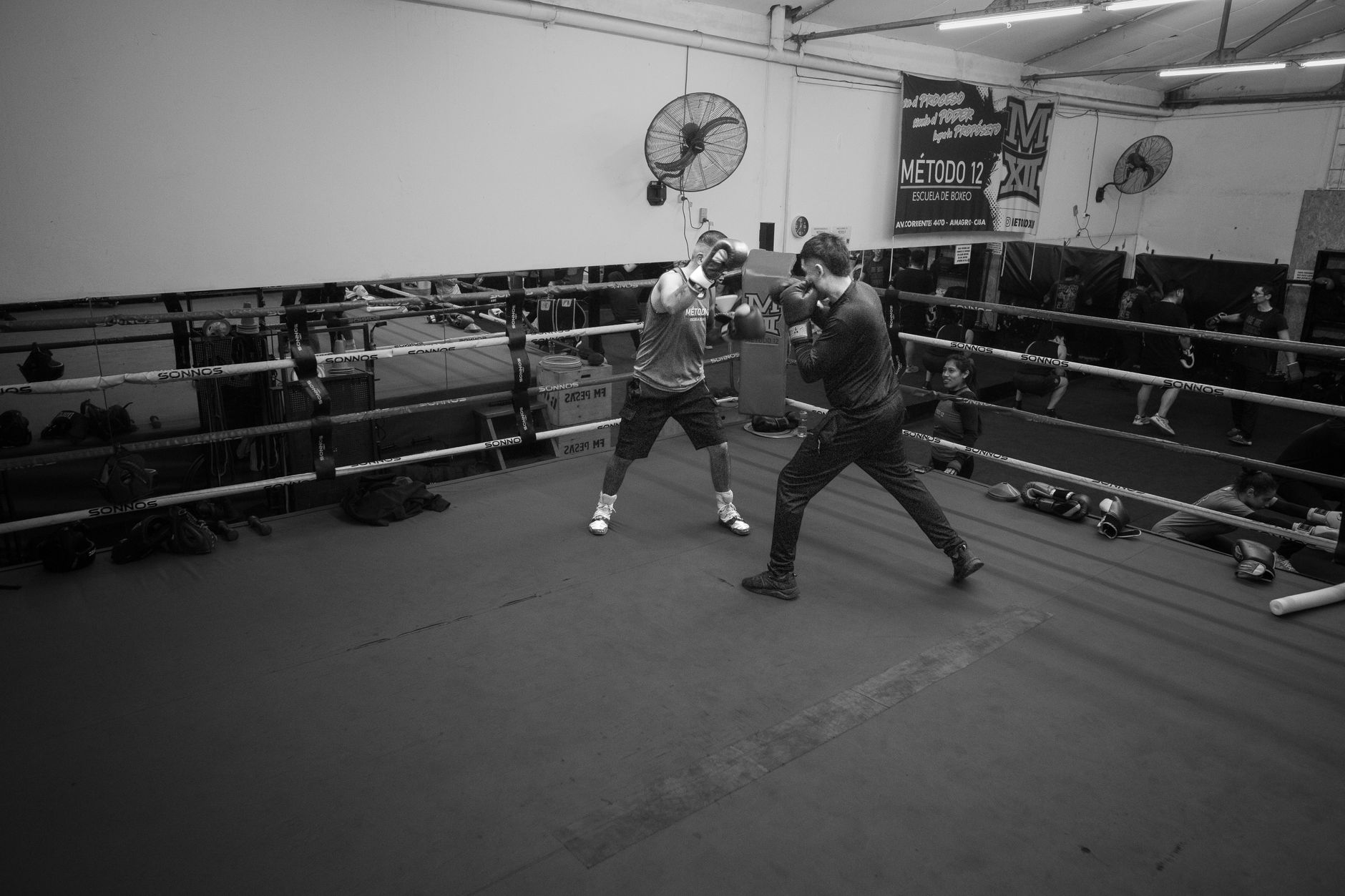 Boxers sparring in an indoor gym in Buenos Aires, Argentina. Intense training atmosphere.