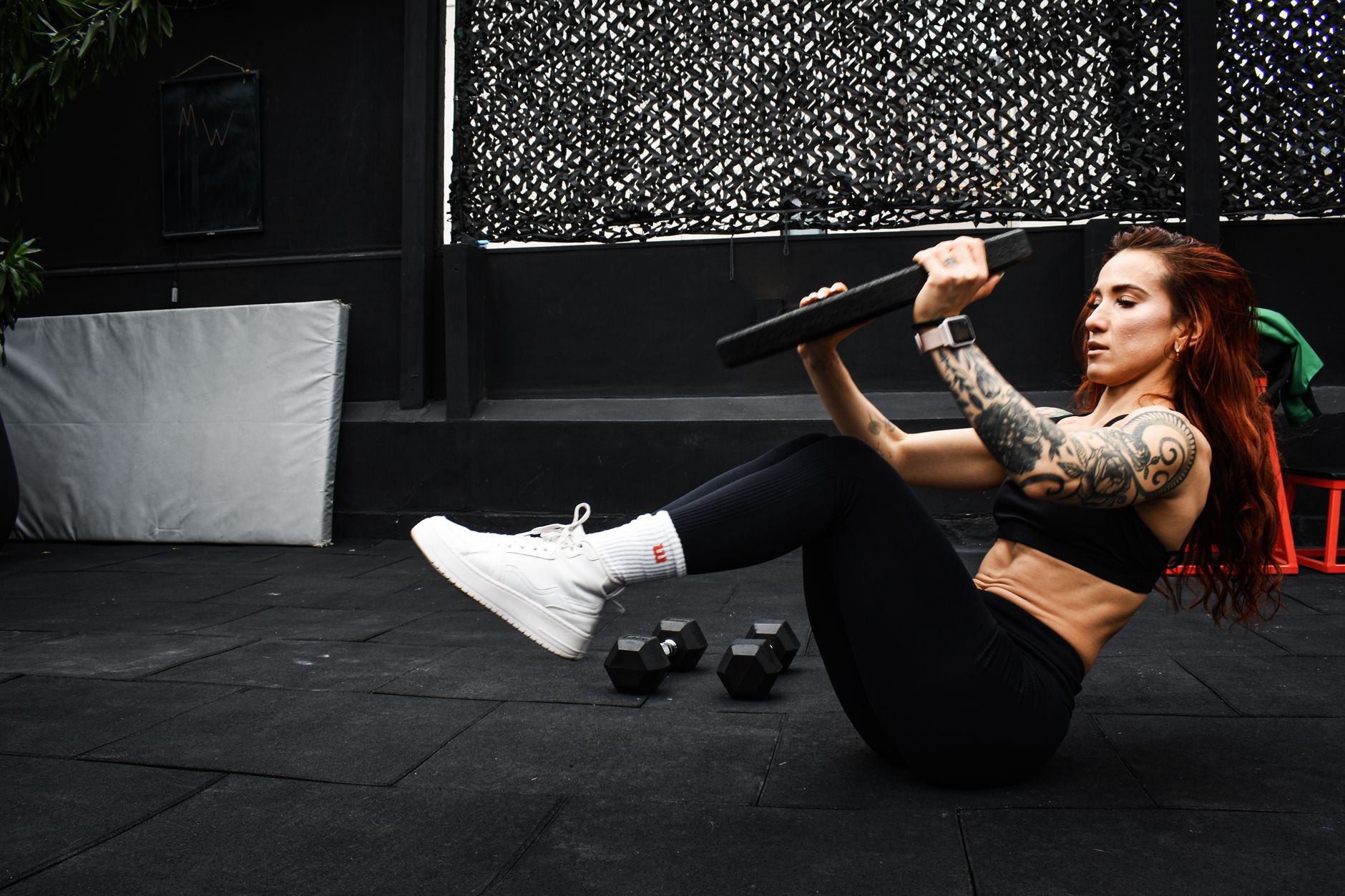 A determined woman performs a core workout in an indoor gym setting.