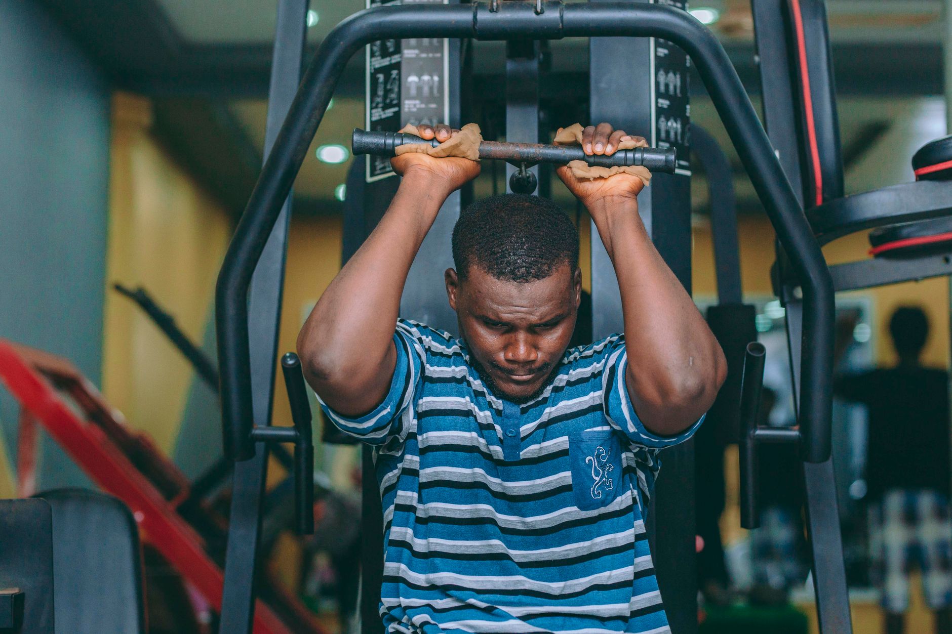 A determined man works out on fitness equipment in a gym in Accra, Ghana.