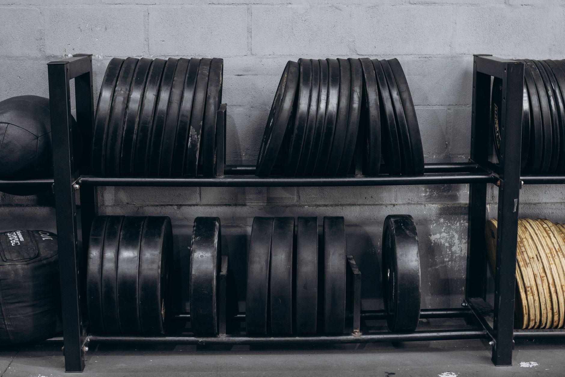 Rows of weight plates on a rack in a gym setting, creating a focused and organized fitness space.