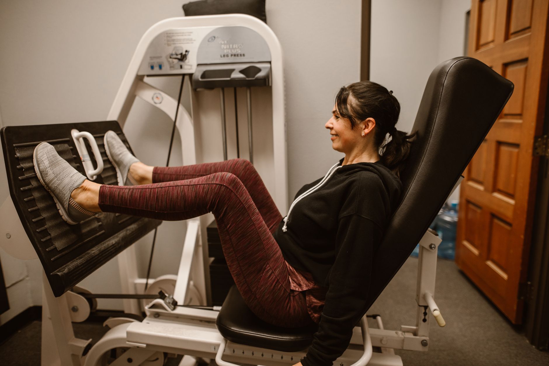 A woman works out on a leg press machine, promoting fitness and a healthy lifestyle
