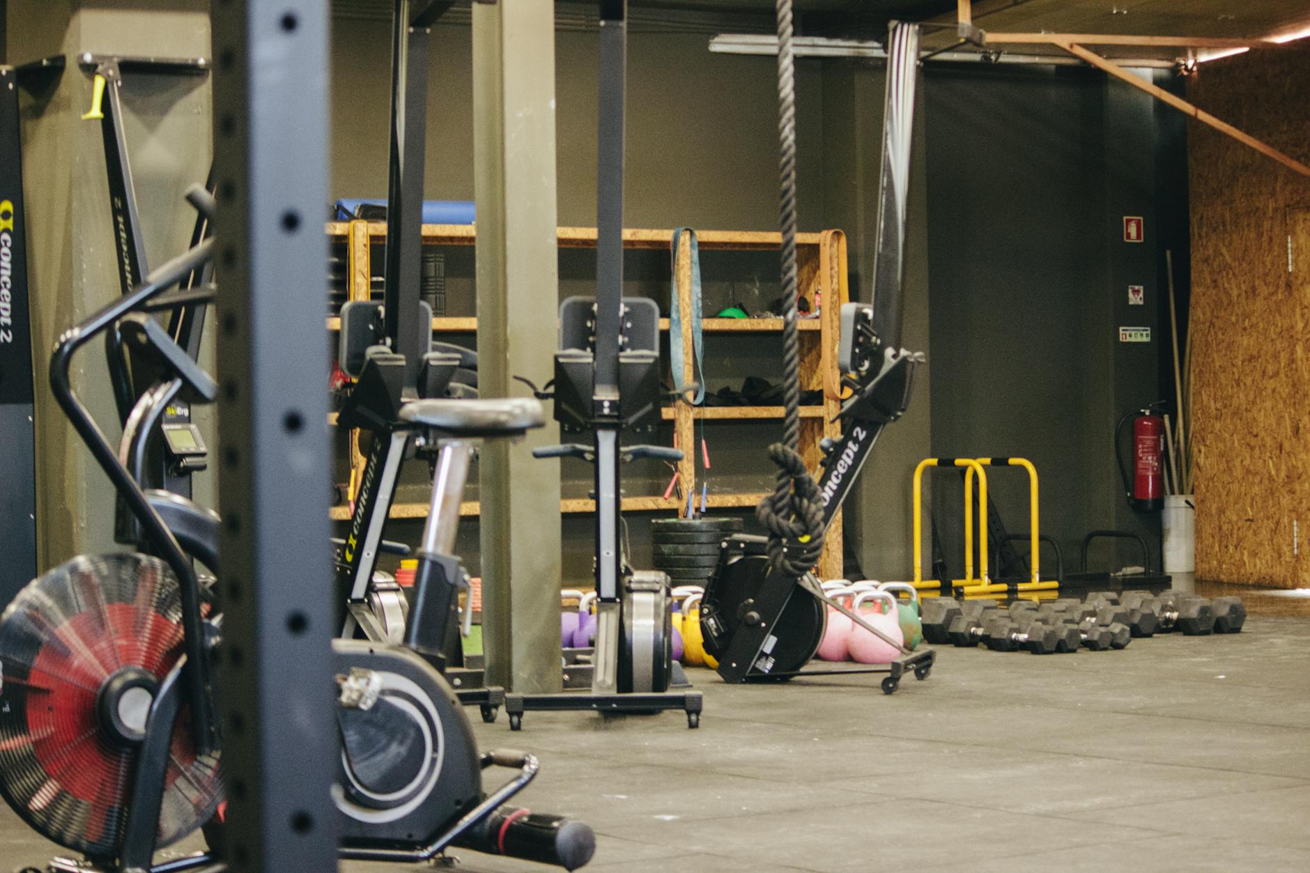 An indoor gym with various exercise equipment and weights ready for workout.