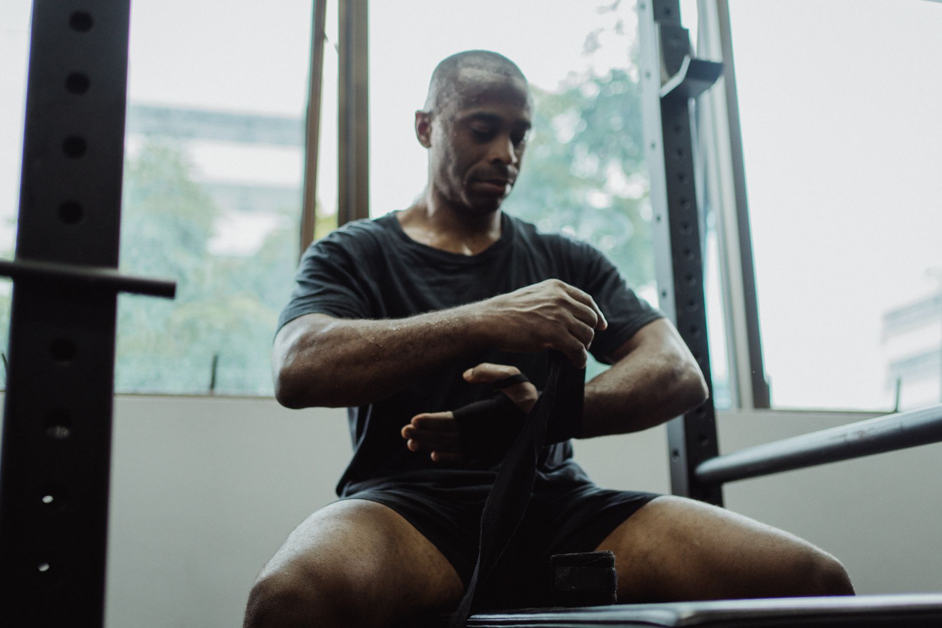 Focused man wrapping his hands before a workout, highlighting fitness and determination.