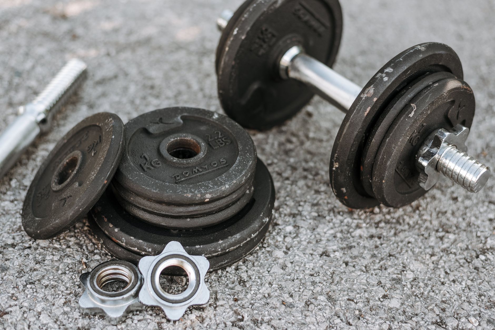 Weathered heavy adjustable dumbbell with details for regulating weight for muscle training on paved ground