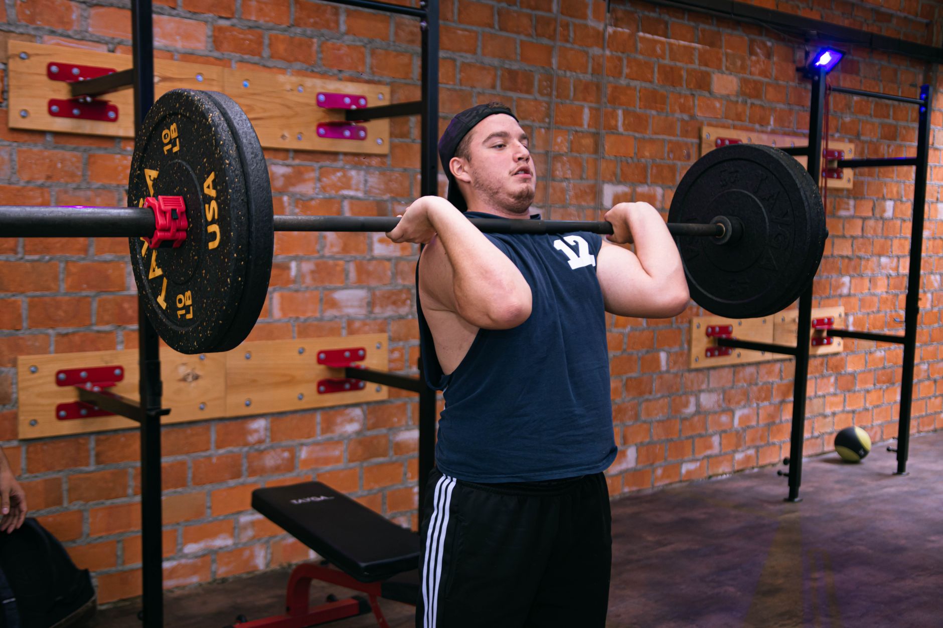 A man focuses on lifting a heavy barbell in a Ciudad de México gym.