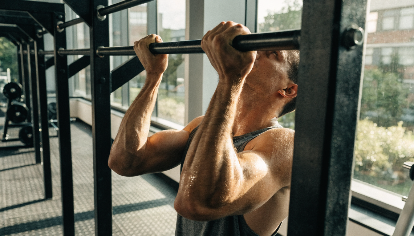 Close-up of dumbbells, jump rope, and water bottle on a yoga mat, ideal for home fitness routines.