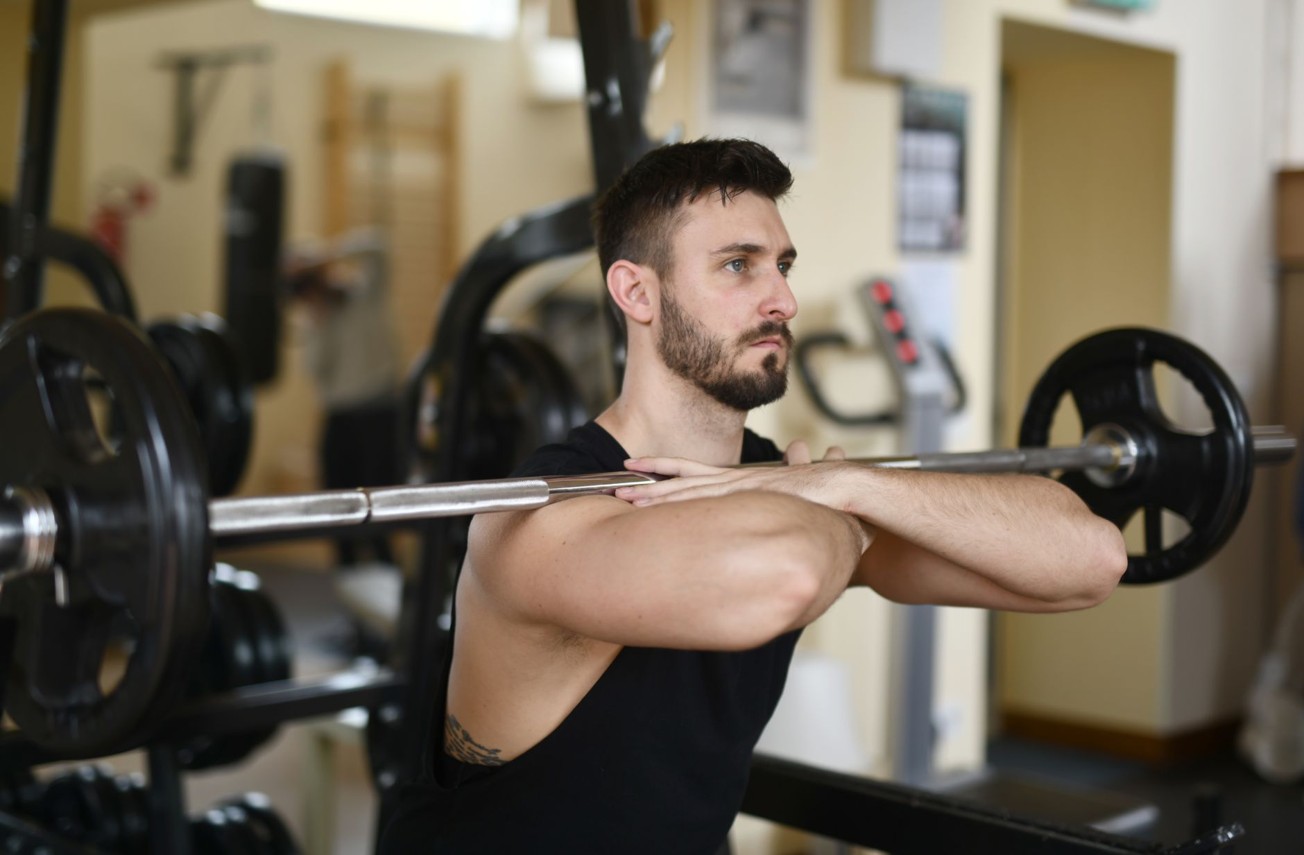 A focused man lifting weights indoors showcasing strength and concentration.