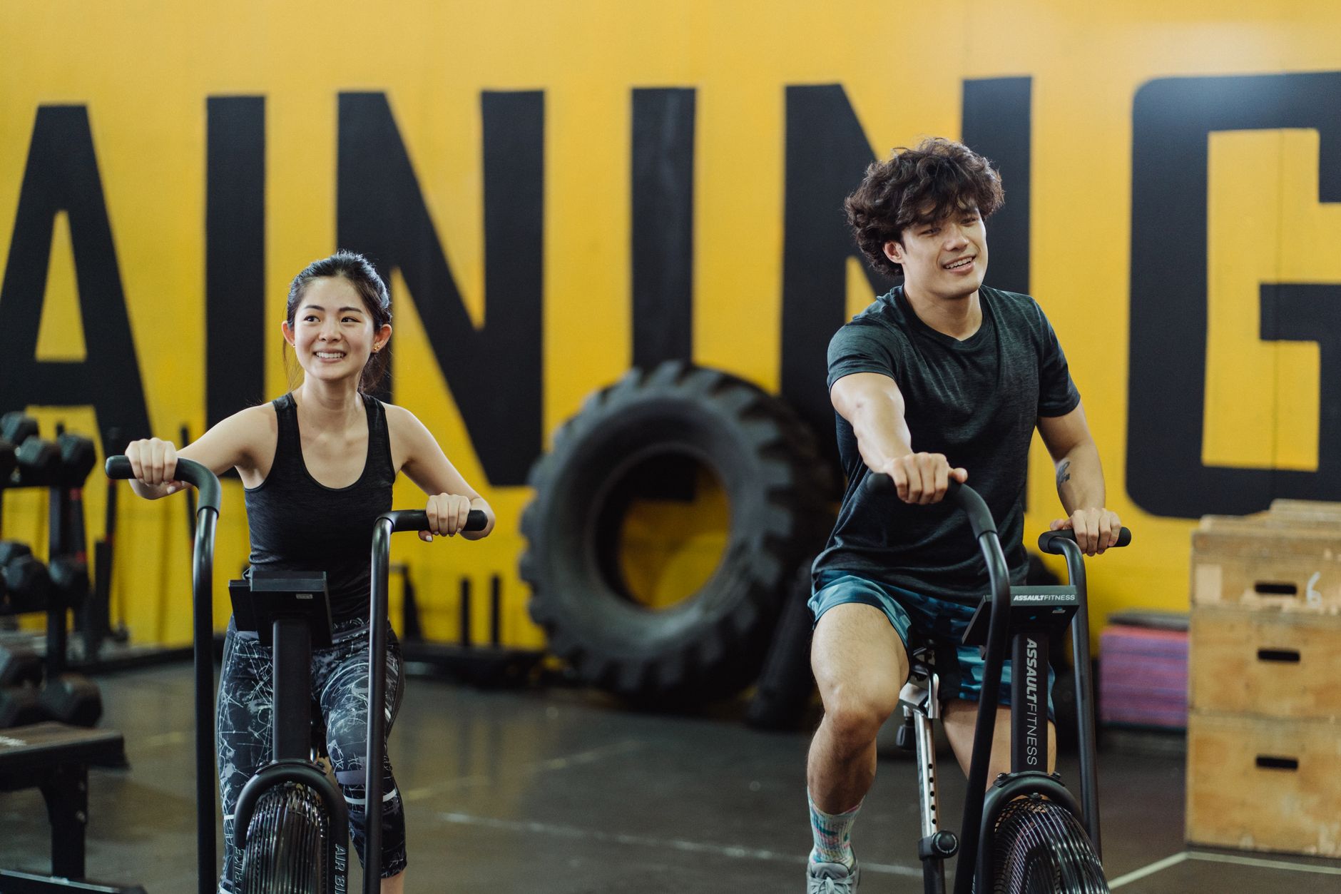 Happy couple enjoying an indoor cycling workout together, enhancing fitness and having fun.