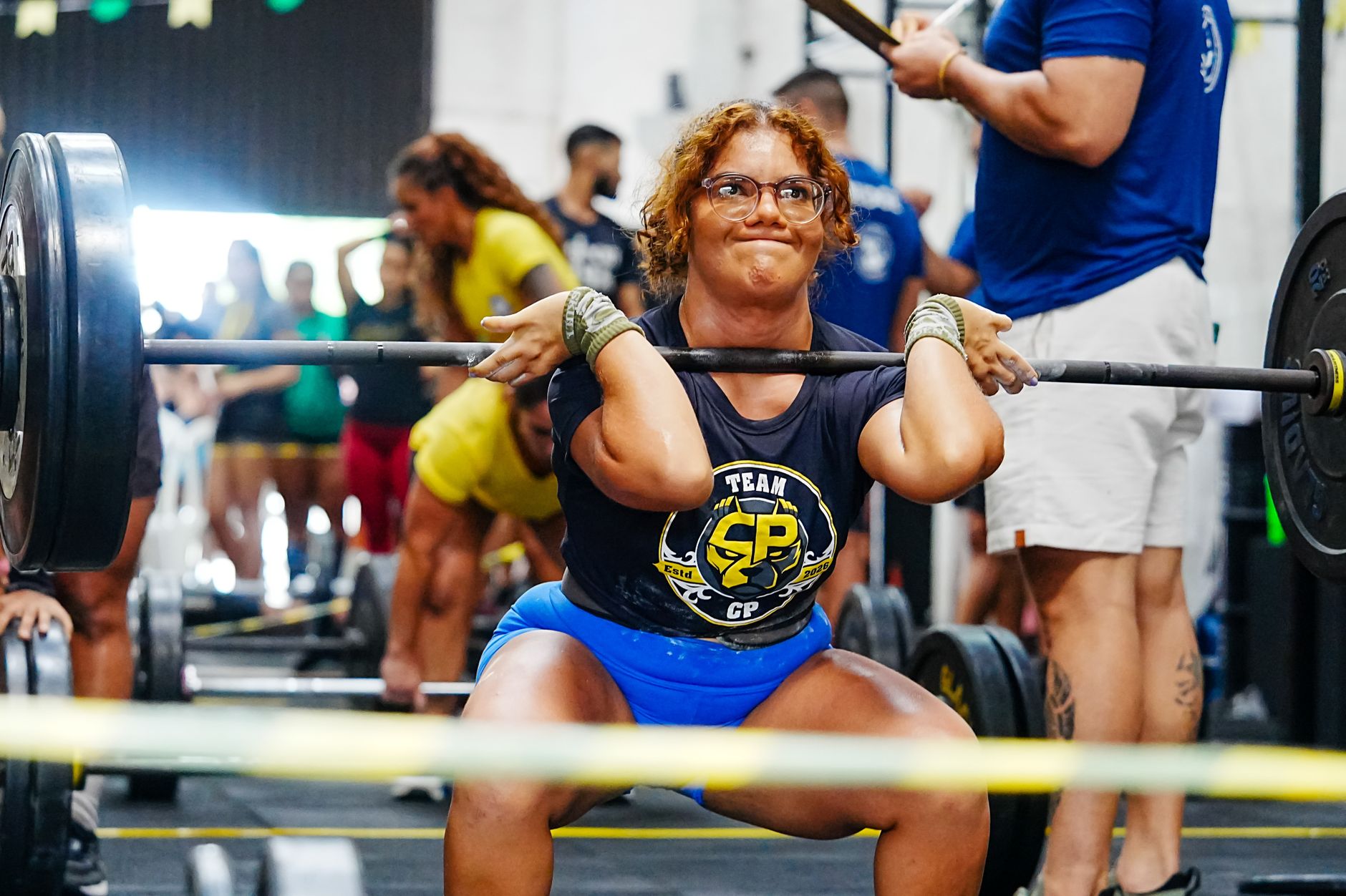 Woman lifting weights in a gym during a competitive event in Natal, Brazil.