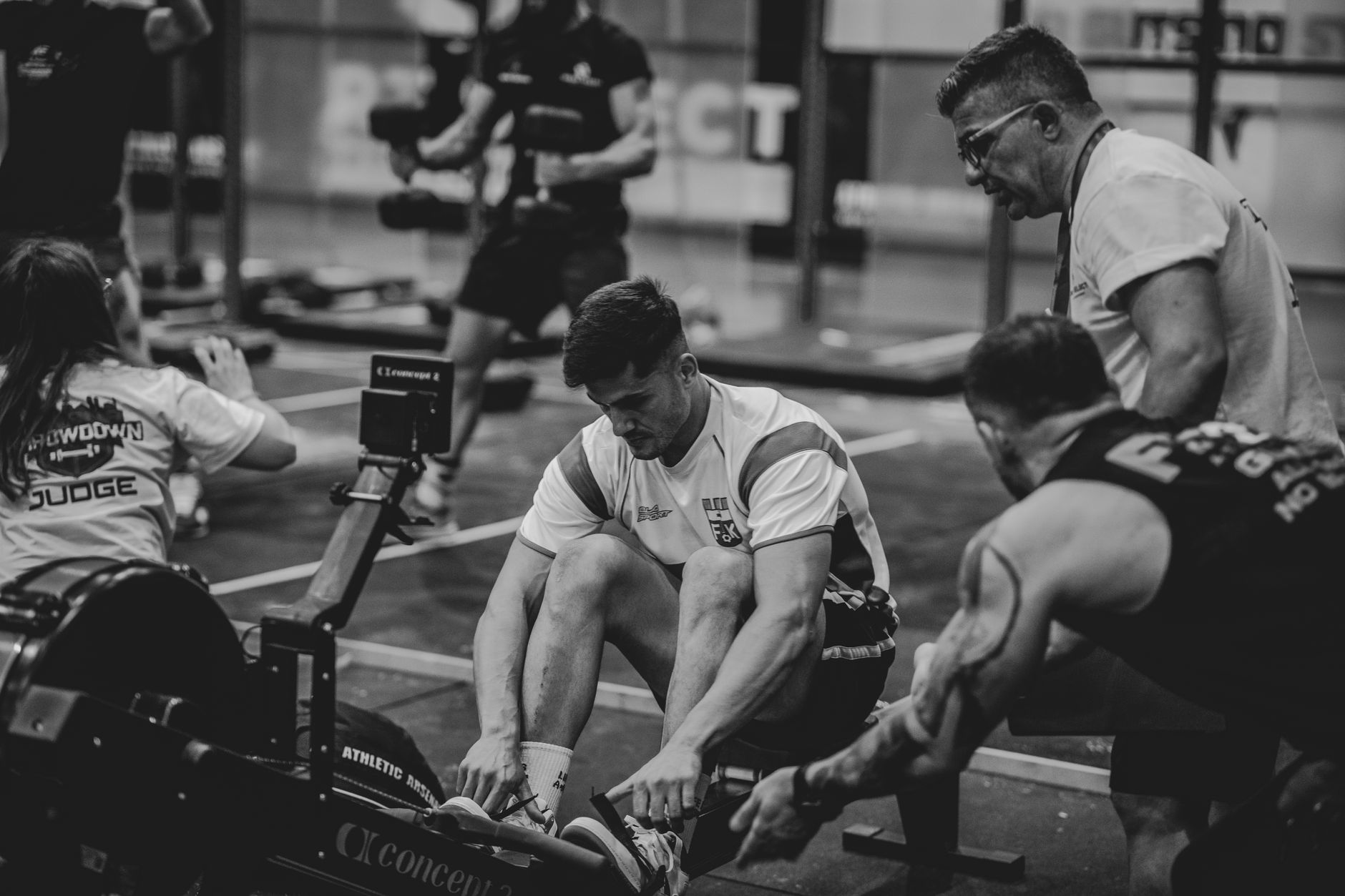 Men engaged in a competitive gym rowing session, highlighting teamwork and fitness.