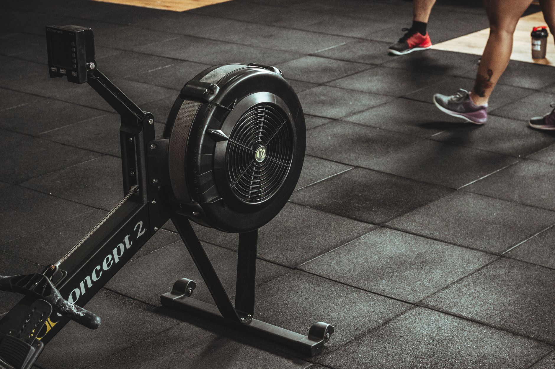 A gym scene featuring fitness equipment and active people exercising indoors.