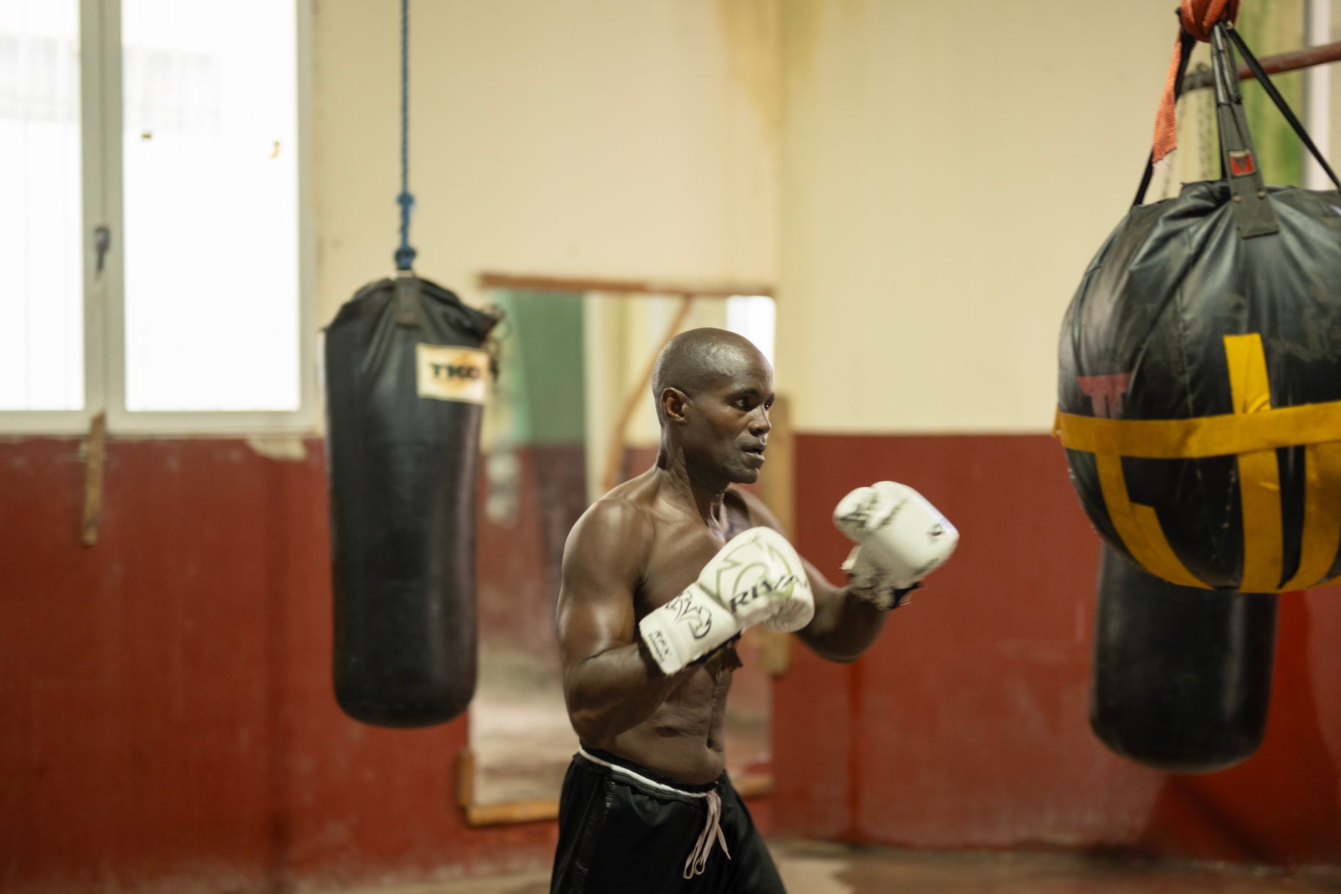 A focused boxer practices in a traditional gym, highlighting Havana's sports culture.