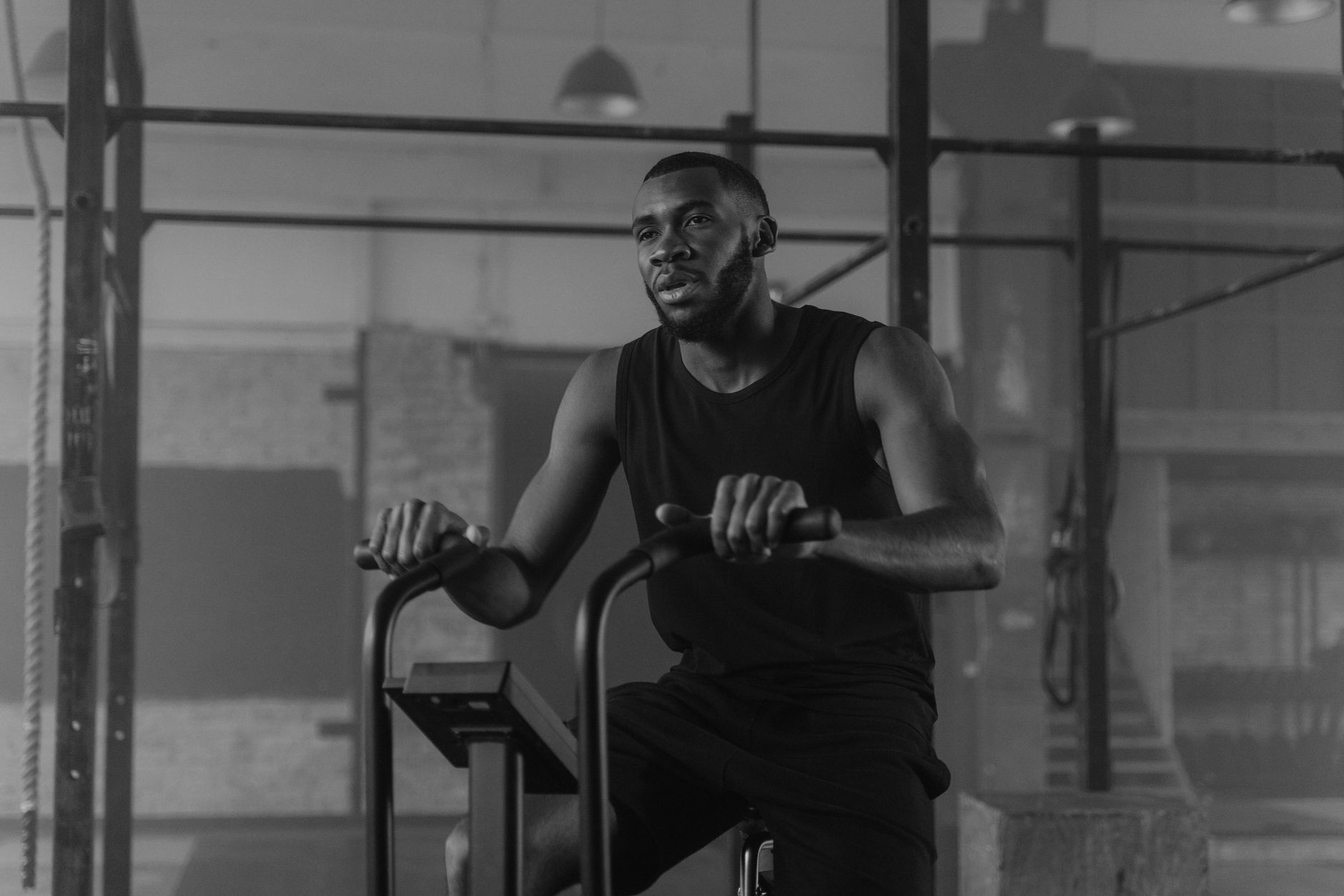 A man stays focused while exercising on a stationary bike in a gym setting, promoting a healthy lifestyle.
