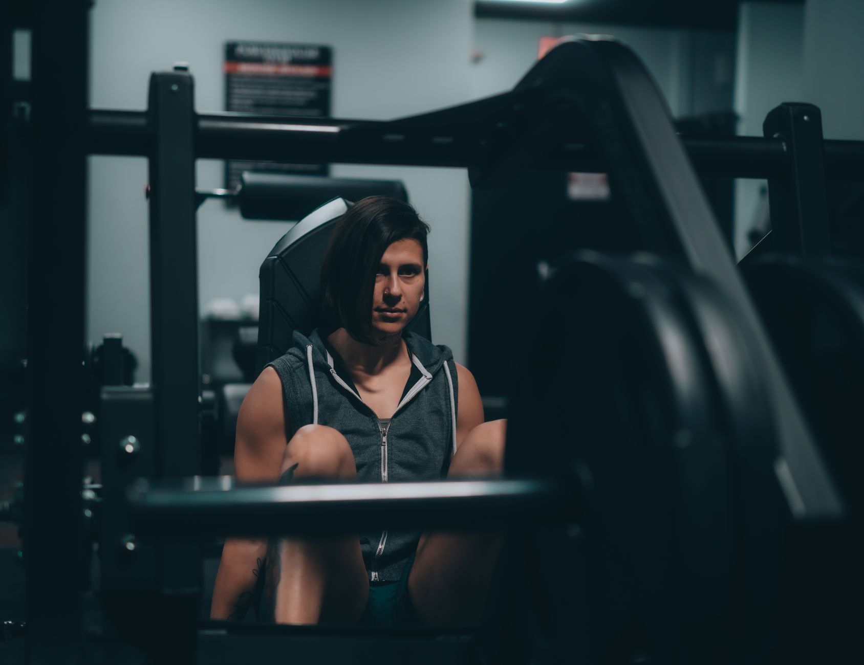 A woman intensely focused while using gym equipment, showcasing strength and determination.