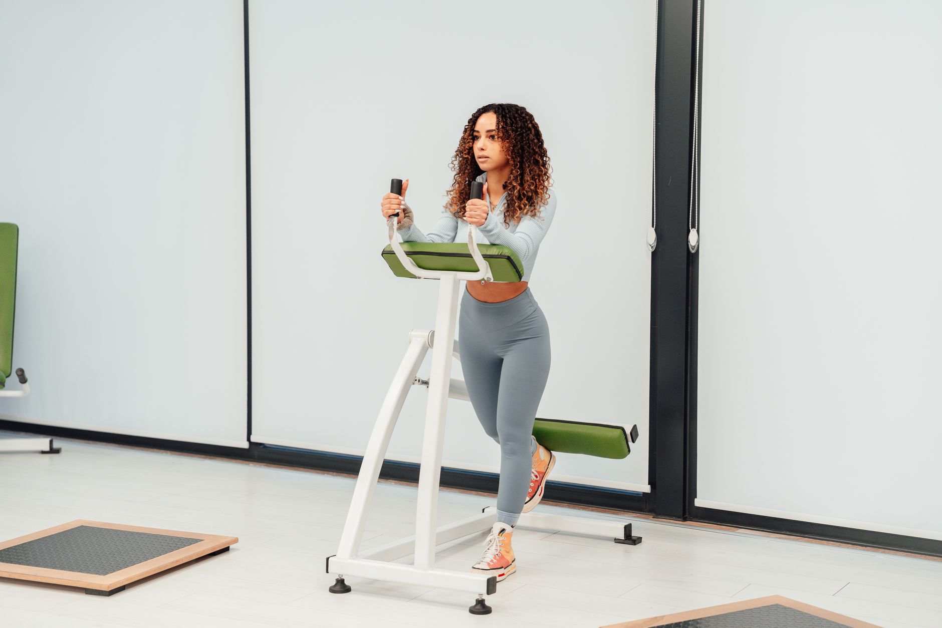 Fit woman working out on exercise machine indoors, showcasing healthy lifestyle.