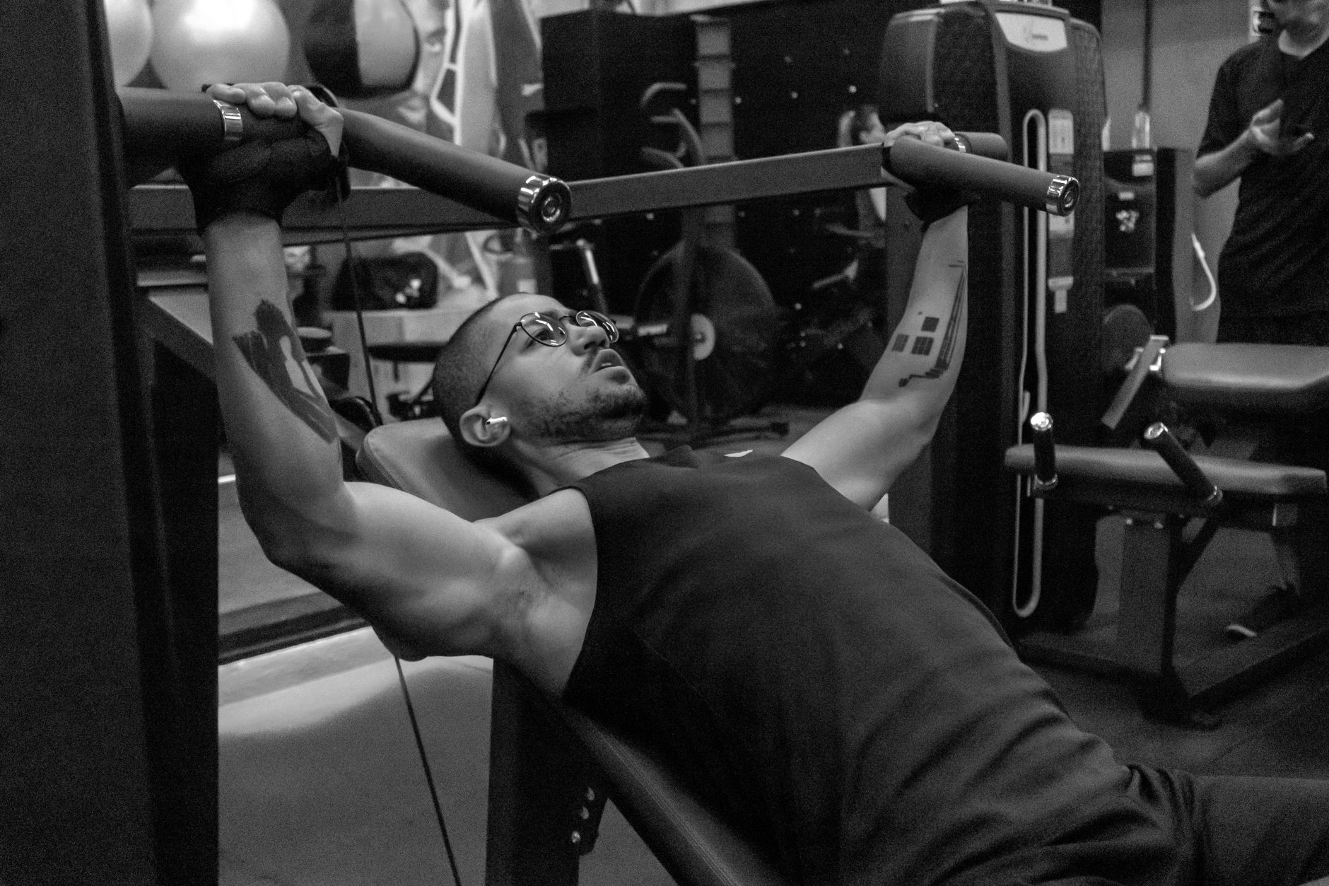 Focused man lifting weights in gym, demonstrating strength and fitness.