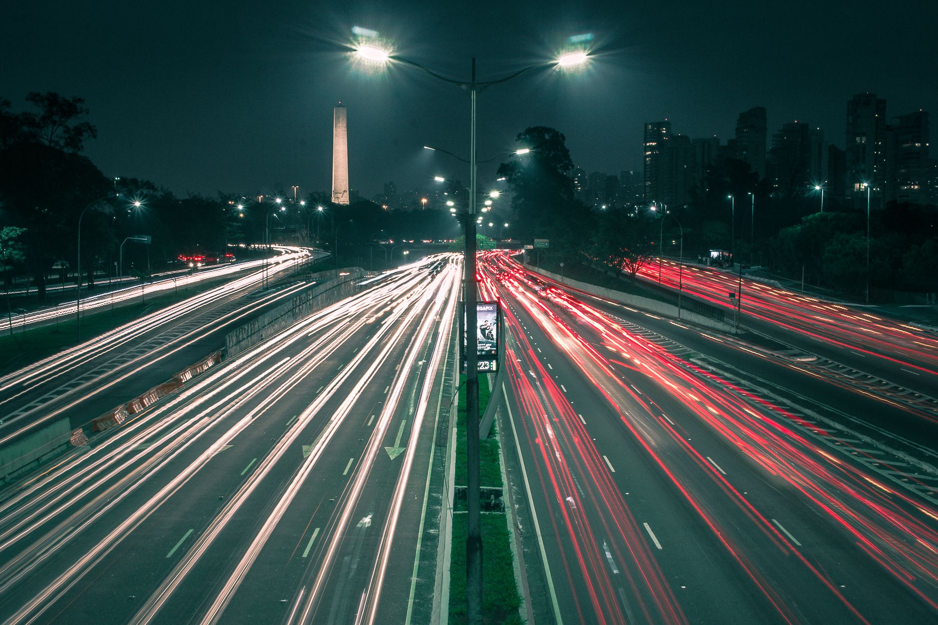 A bustling night shot of São Paulo's expressway with vibrant light trails and city skyline.