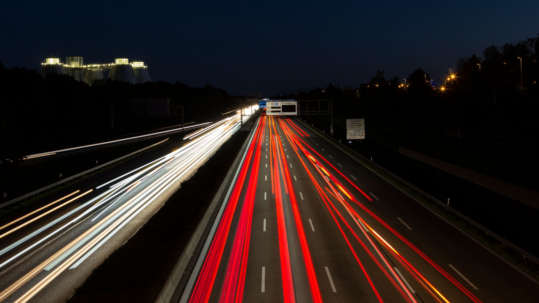 Long exposure of vibrant light trails on a bustling expressway at night.