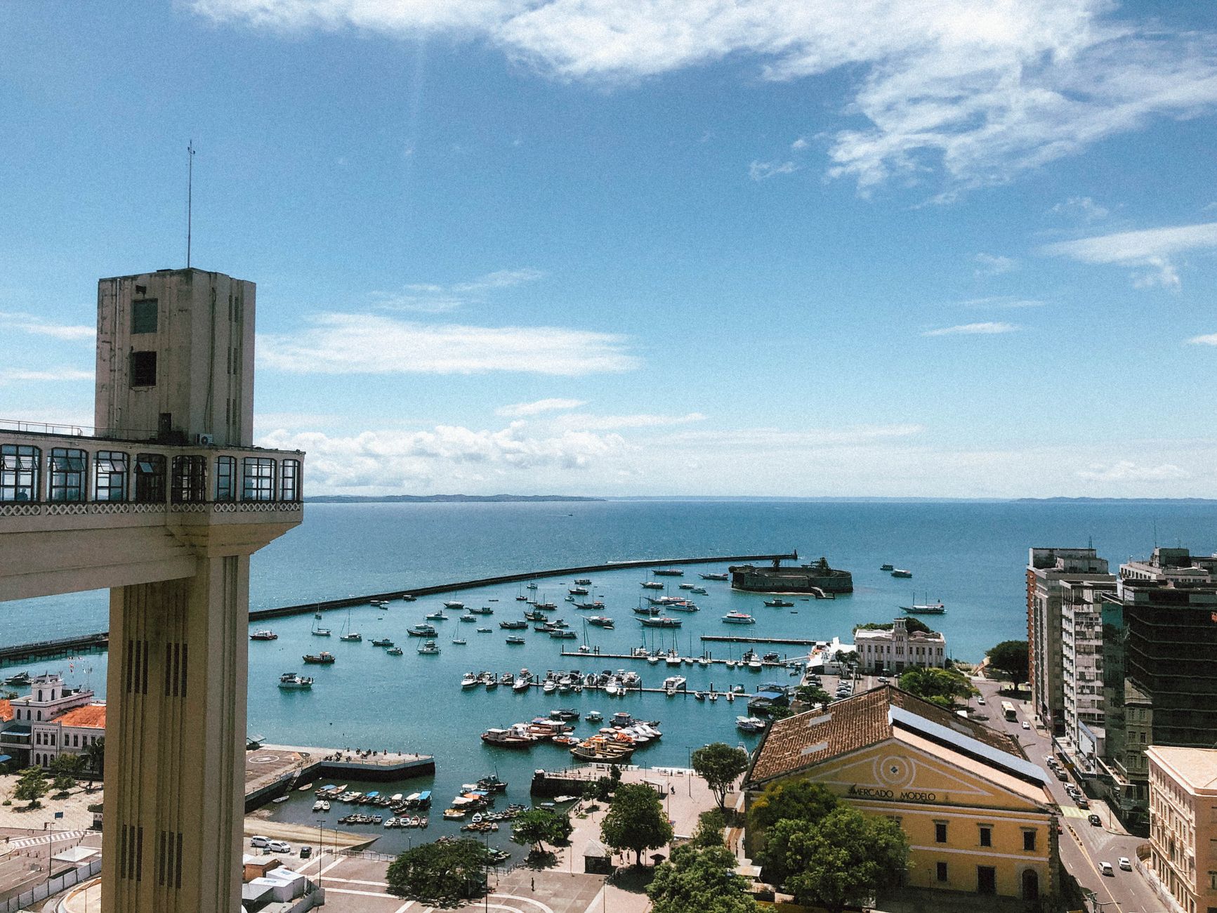 A breathtaking view of Salvador's vibrant harbor and the iconic Lacerda Elevator on a sunny day.