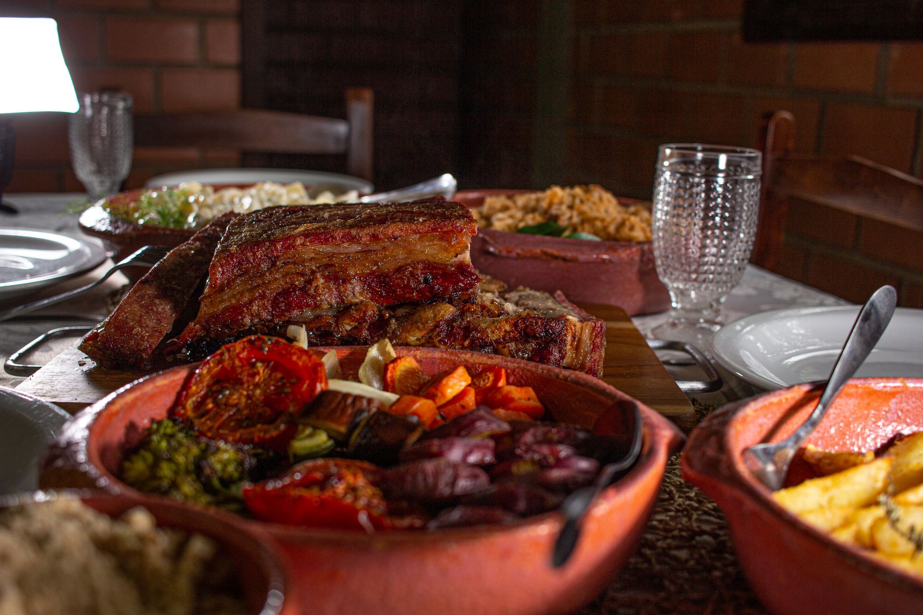 Table set with succulent grilled ribs and vibrant roasted vegetables for a hearty meal.