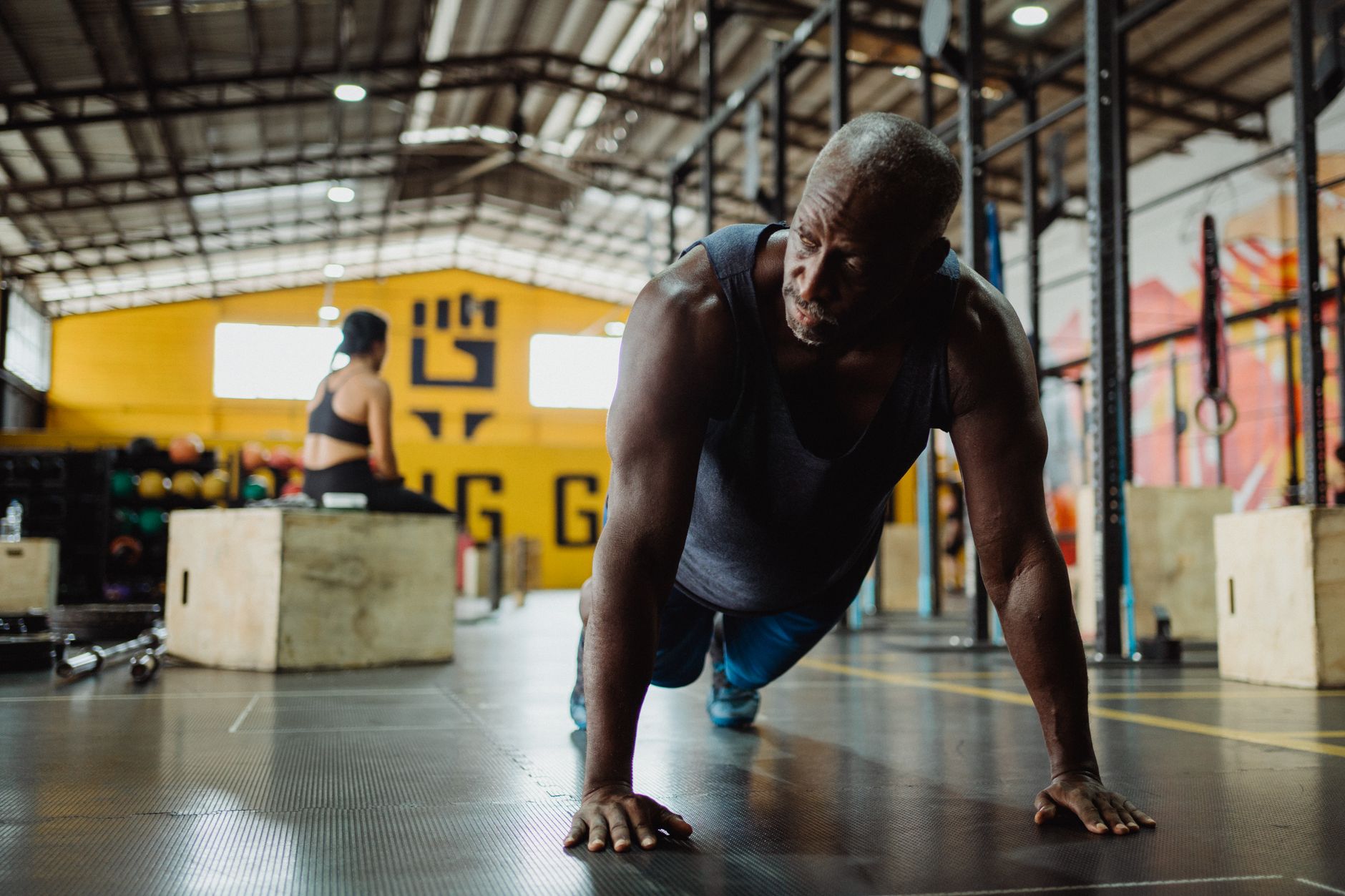 Senior man performing push-ups indoors, embodying fitness and determination.