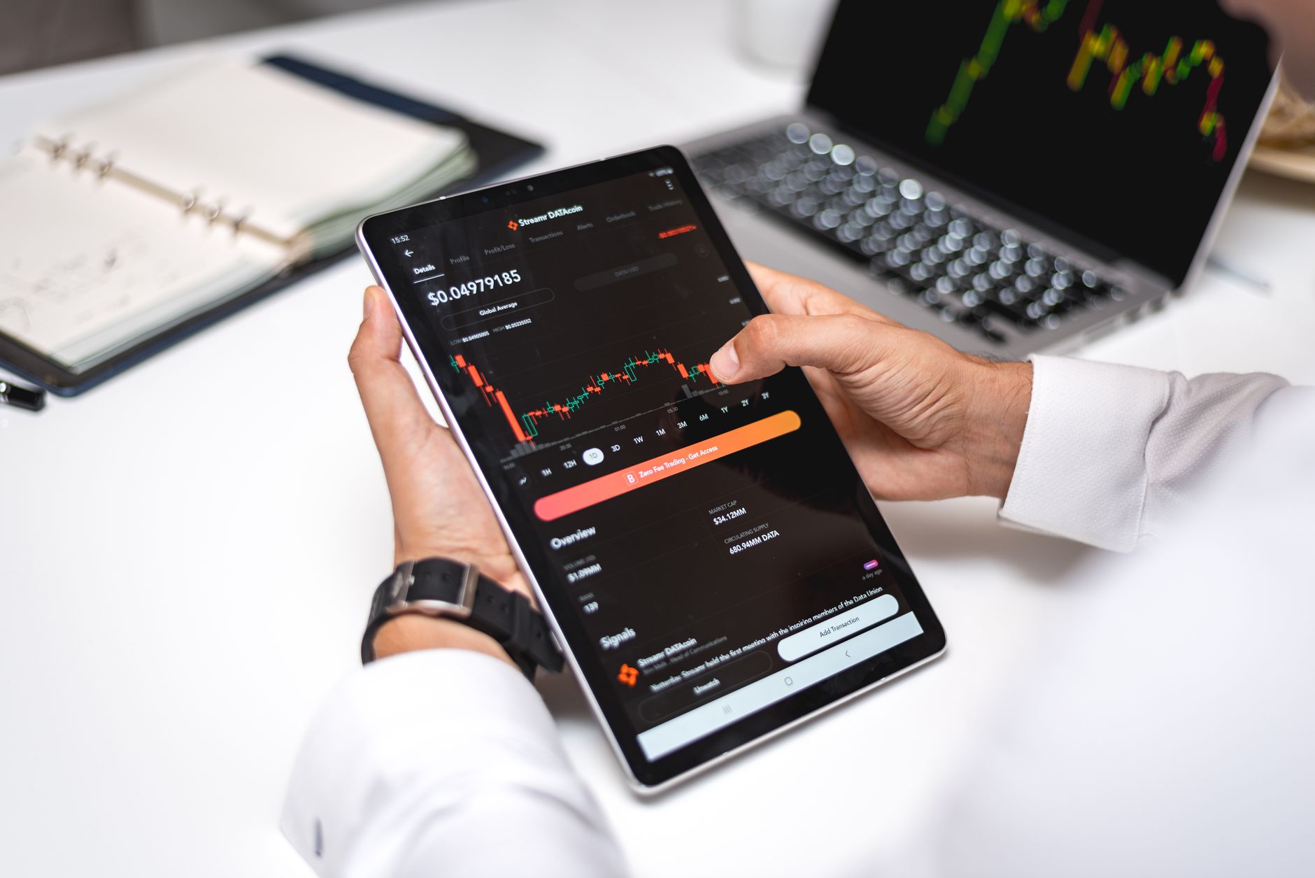 Professional analyzing cryptocurrency market data on a digital tablet with financial graphs.