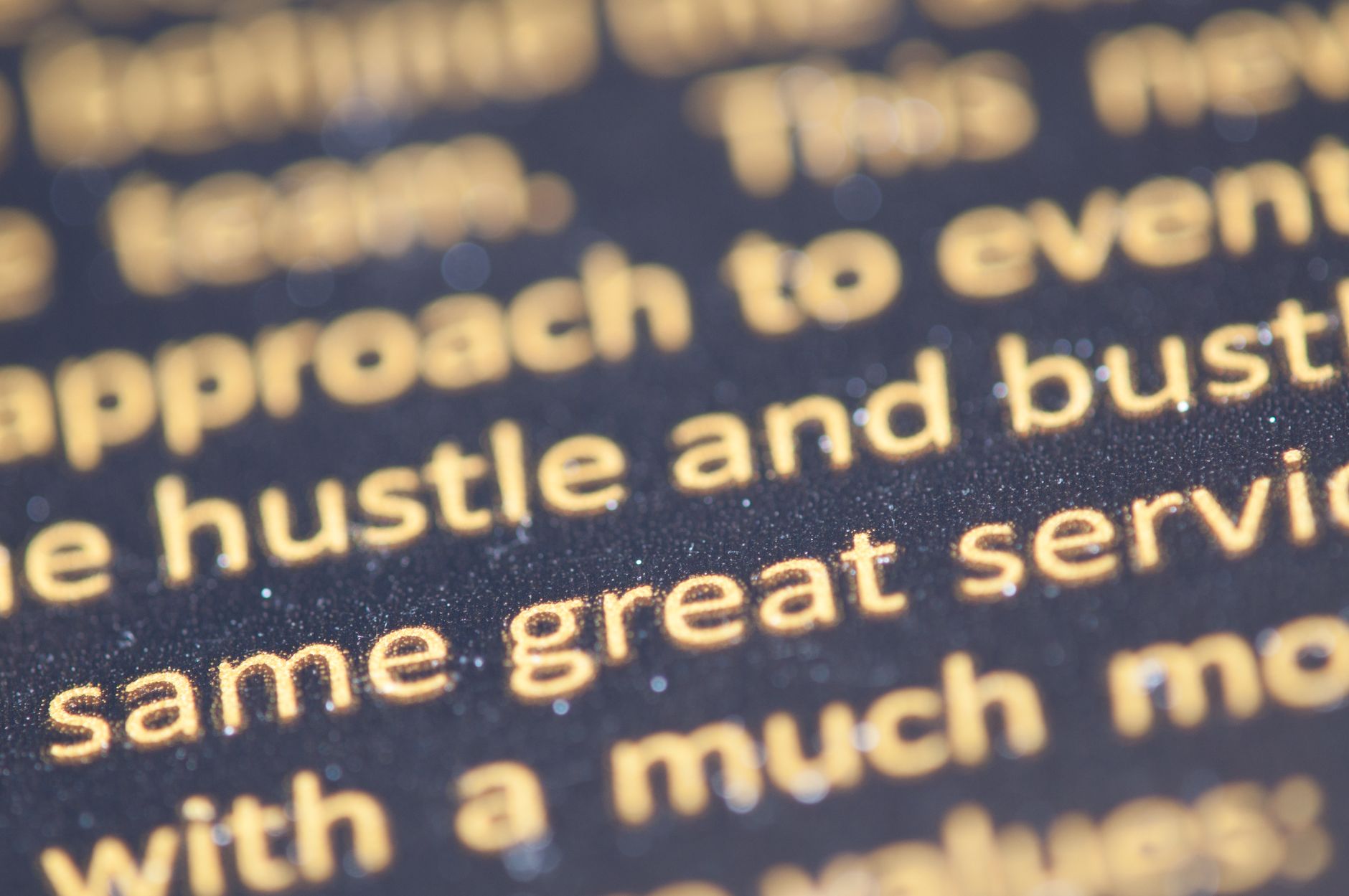 Macro shot of golden text highlighting typography on a dark background.