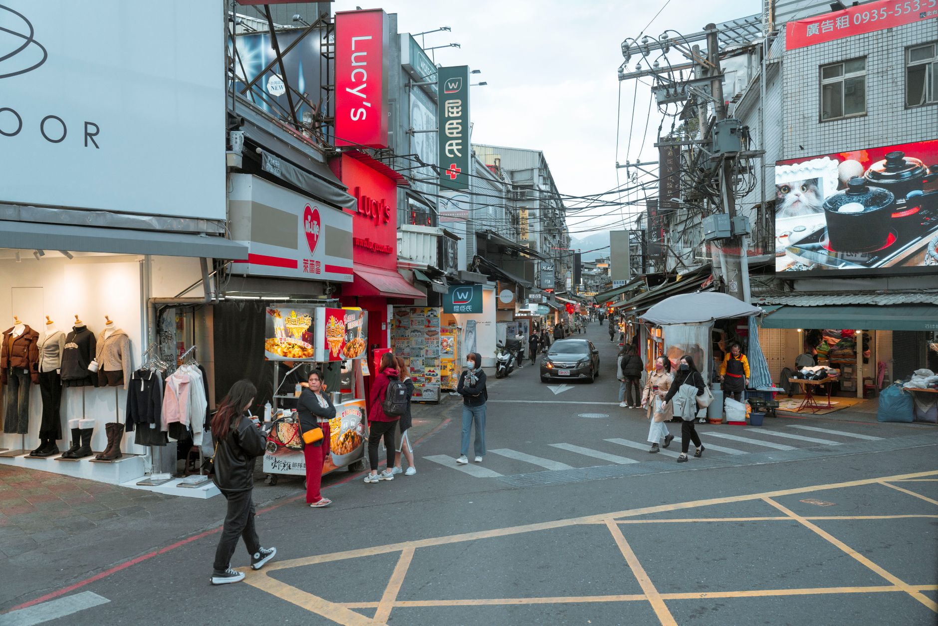 Lively city street in Taiwan featuring pedestrians, shops, and local signage in a vibrant urban setting.