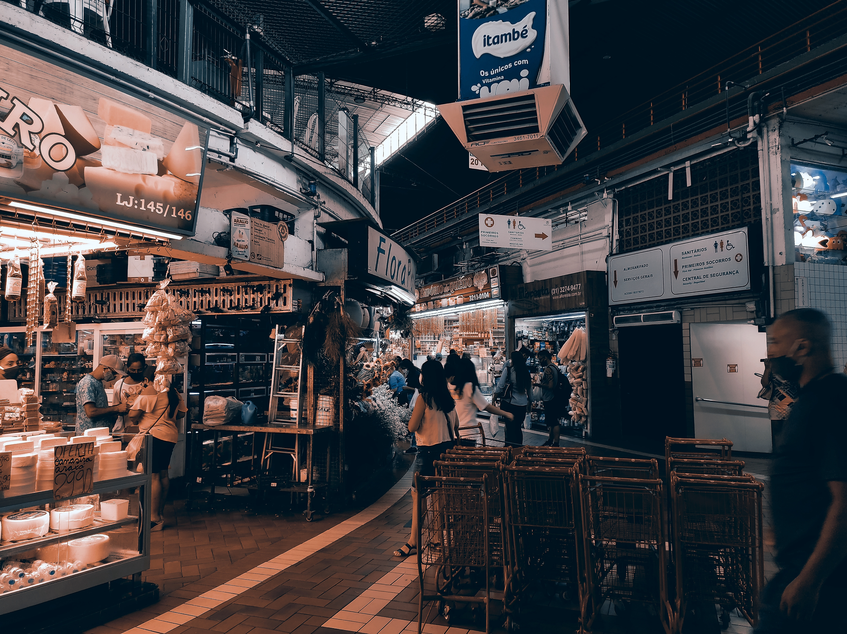 Vibrant indoor market filled with shoppers, food stalls, and lighting. Captures urban market vibe.