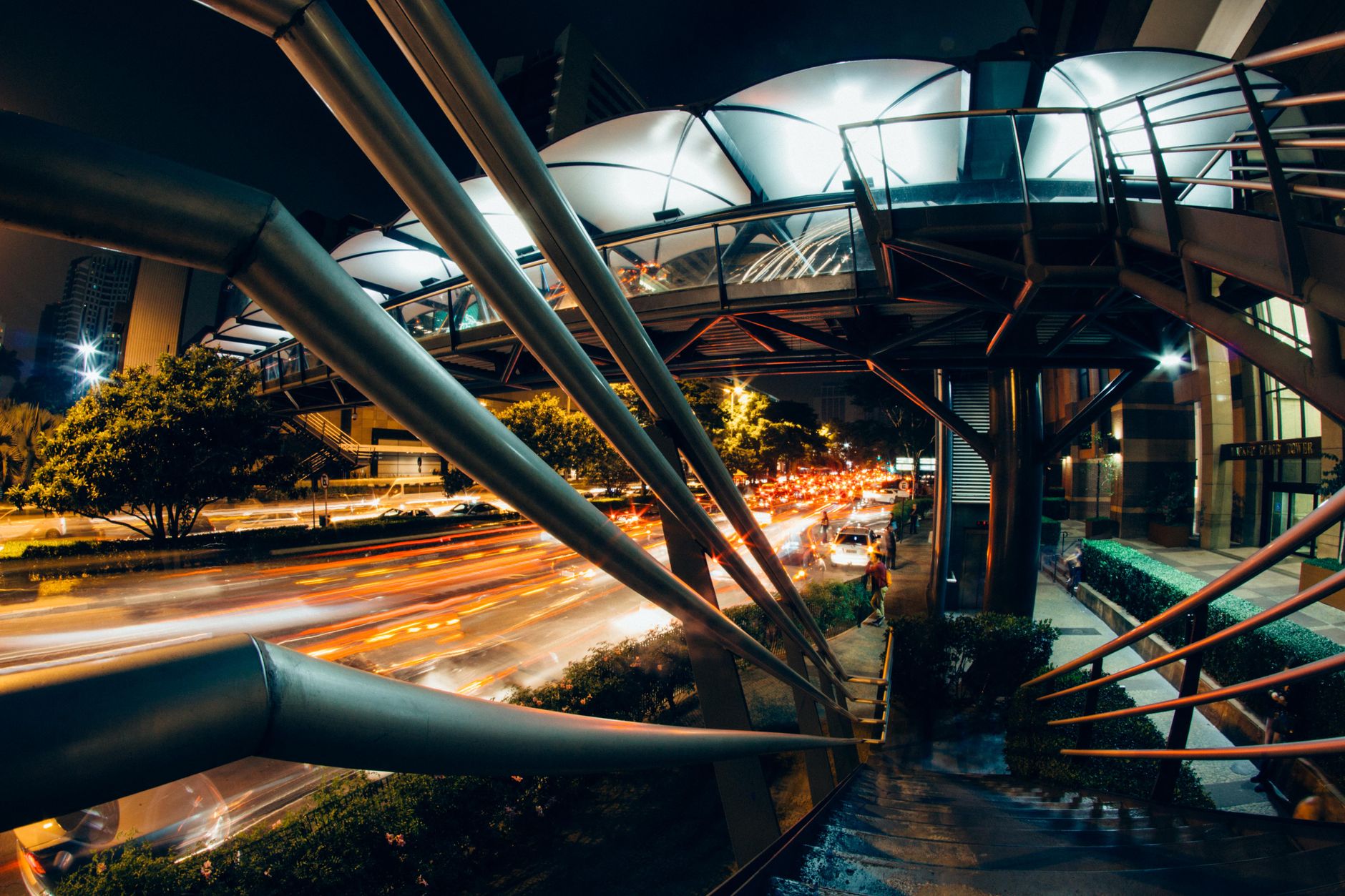 Dynamic cityscape at night featuring a modern bridge and bustling traffic below.