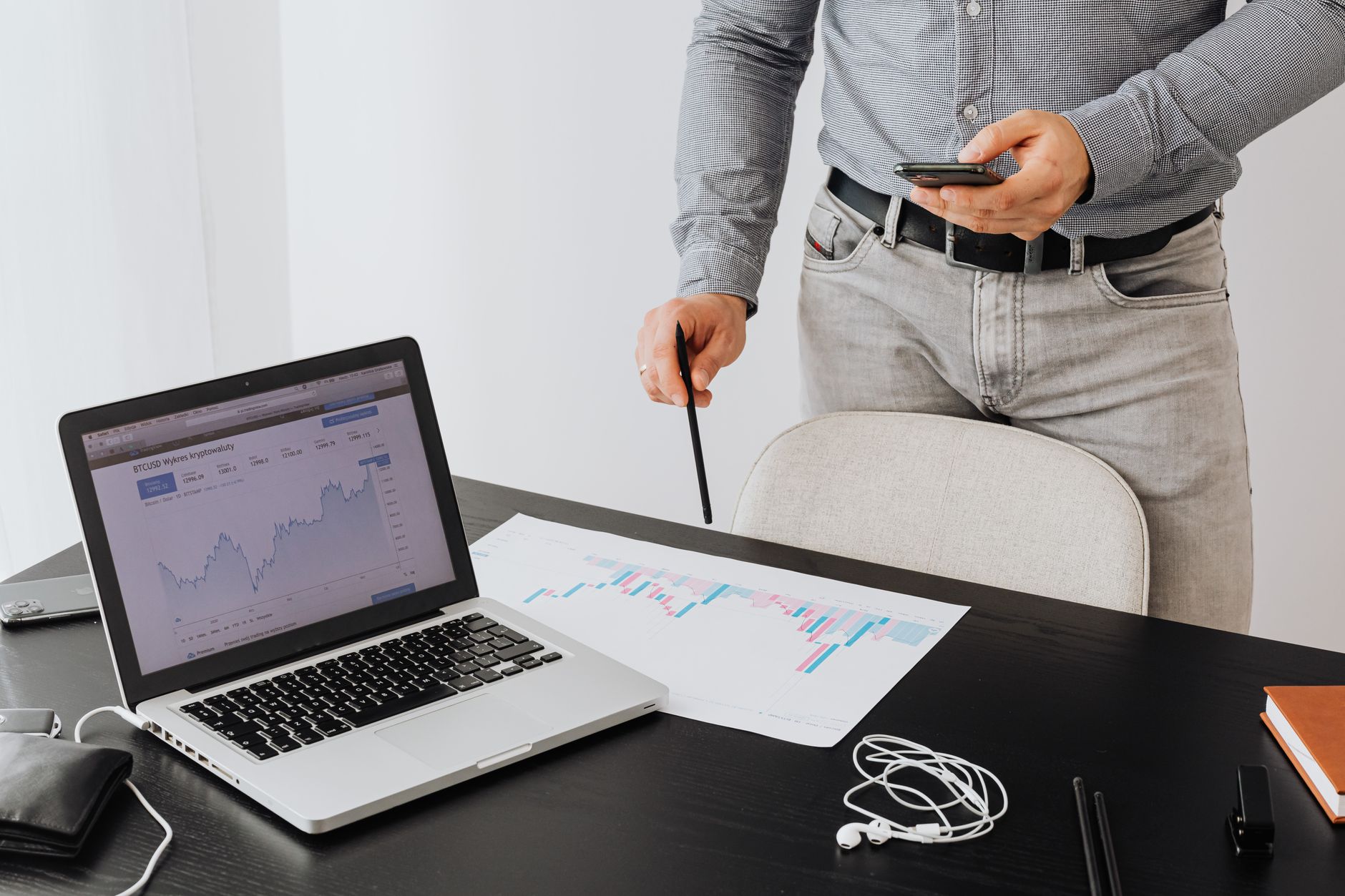 Business professional analyzing cryptocurrency trends on a laptop with graphs and charts.