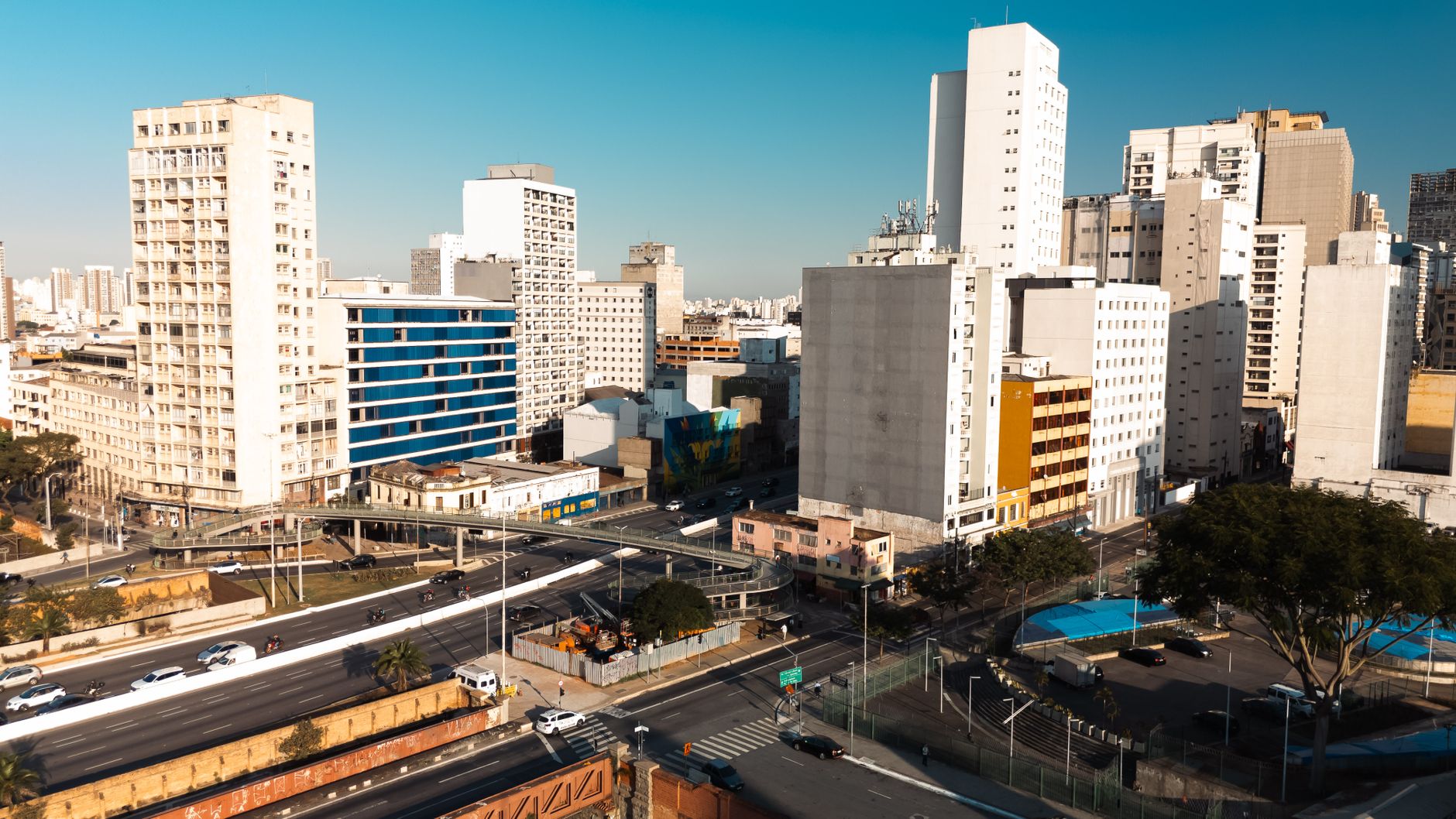 Aerial view of São Paulo's modern buildings and urban layout under a clear blue sky.