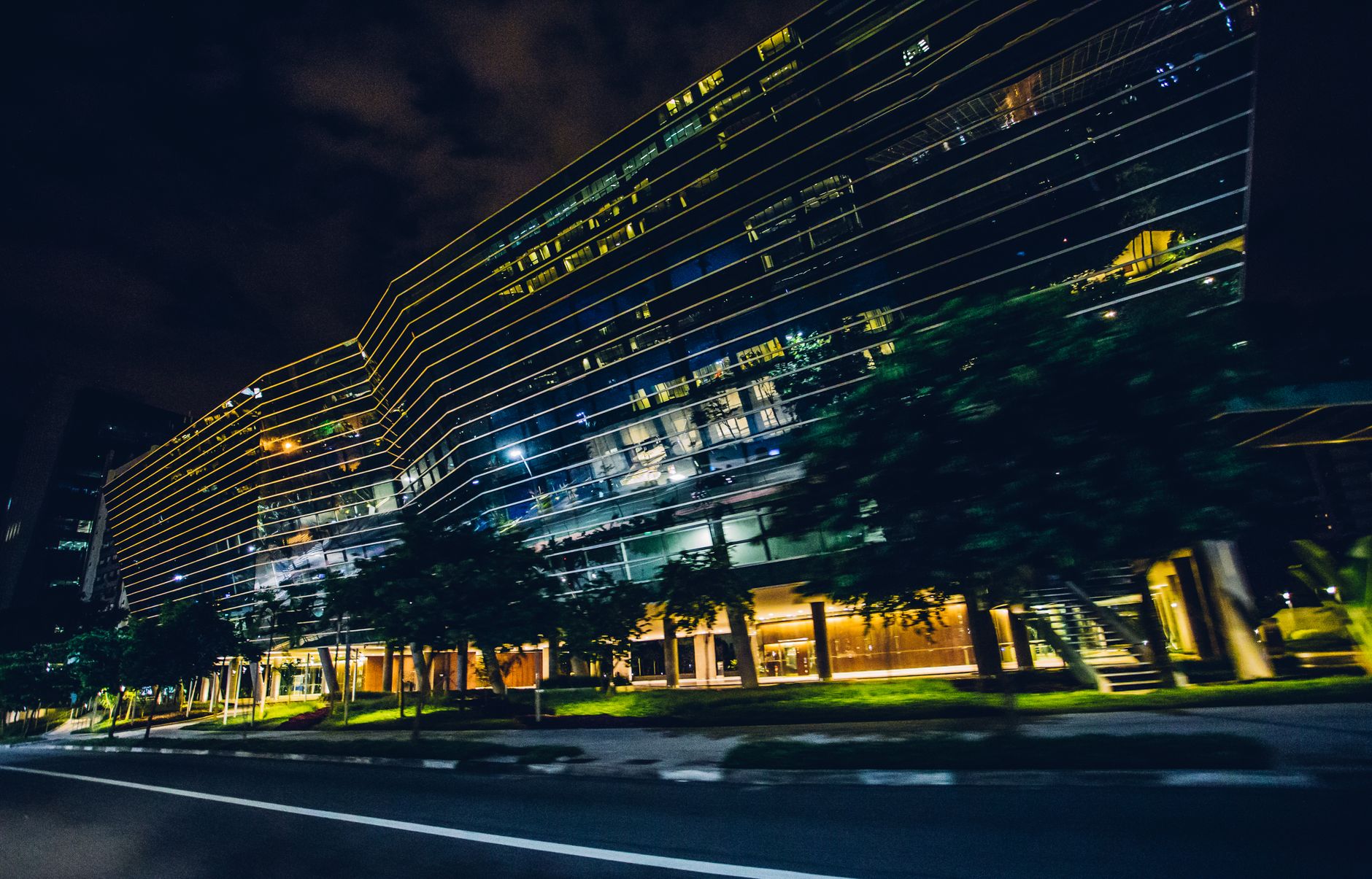 Blurred motion captures a modern building at night in an urban setting.