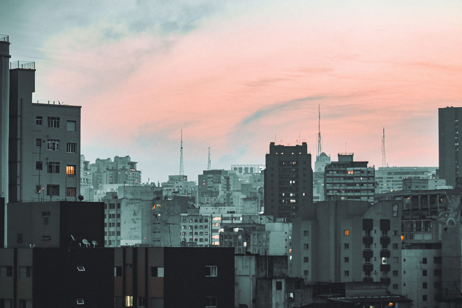 Cityscape view of São Paulo's skyline at dusk, showcasing urban architecture and a vibrant sunset.