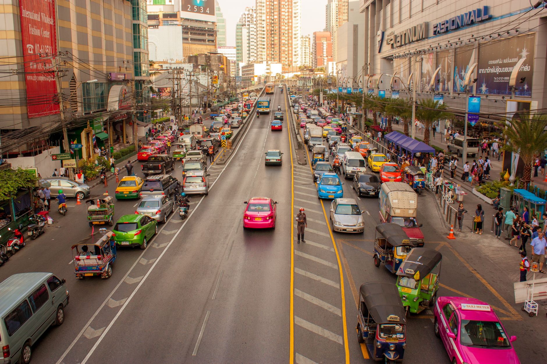 A busy street in Bangkok with vibrant traffic and bustling vendors, showcasing urban life.