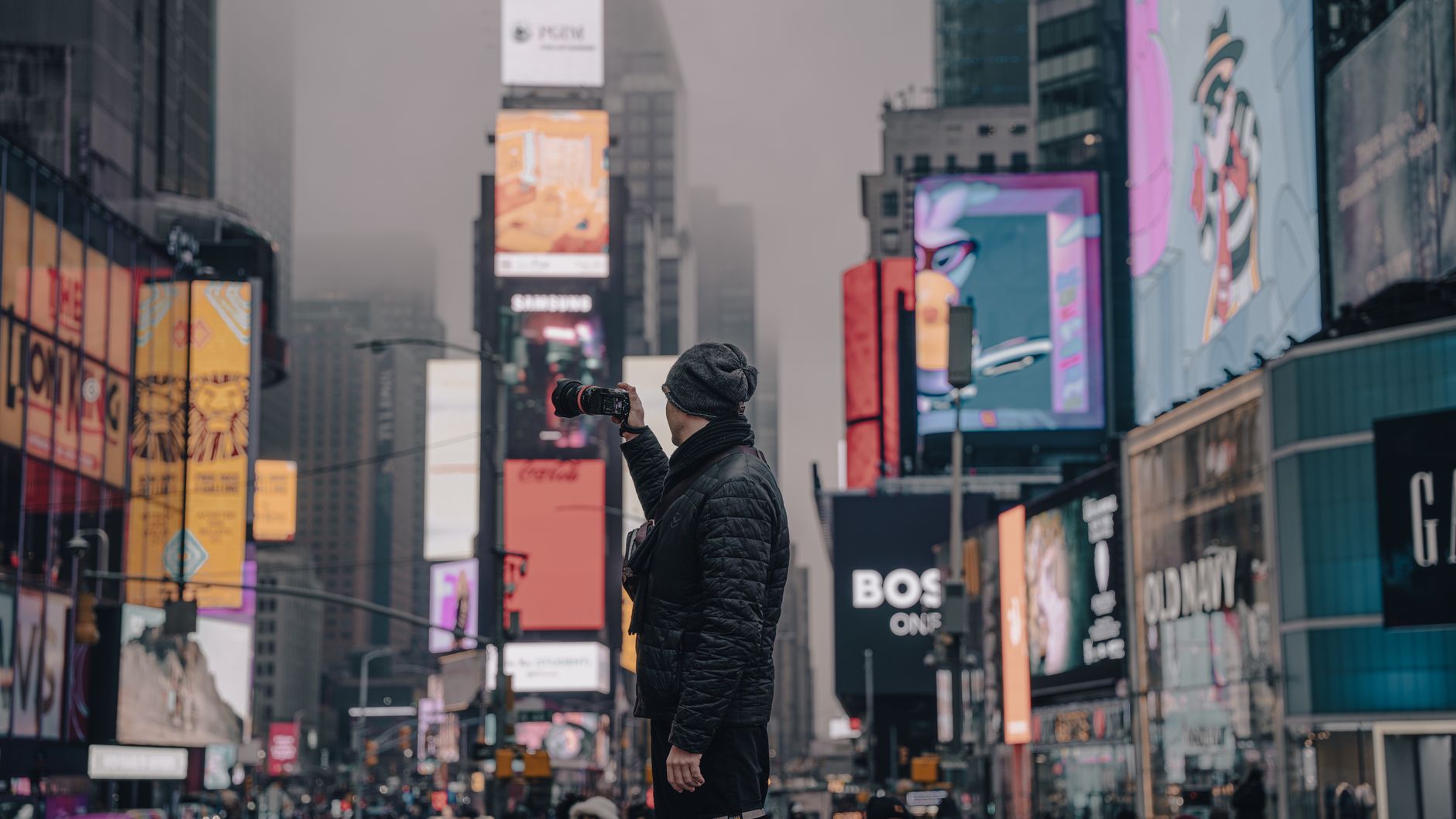 Photographer capturing the bustling atmosphere of Times Square, New York City.