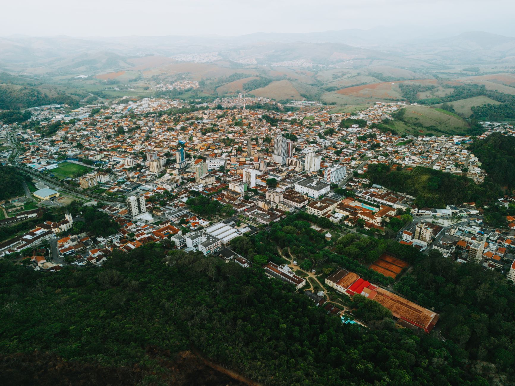 Stunning aerial view of Caxambu, Brazil, showcasing urban landscape and surrounding hills.