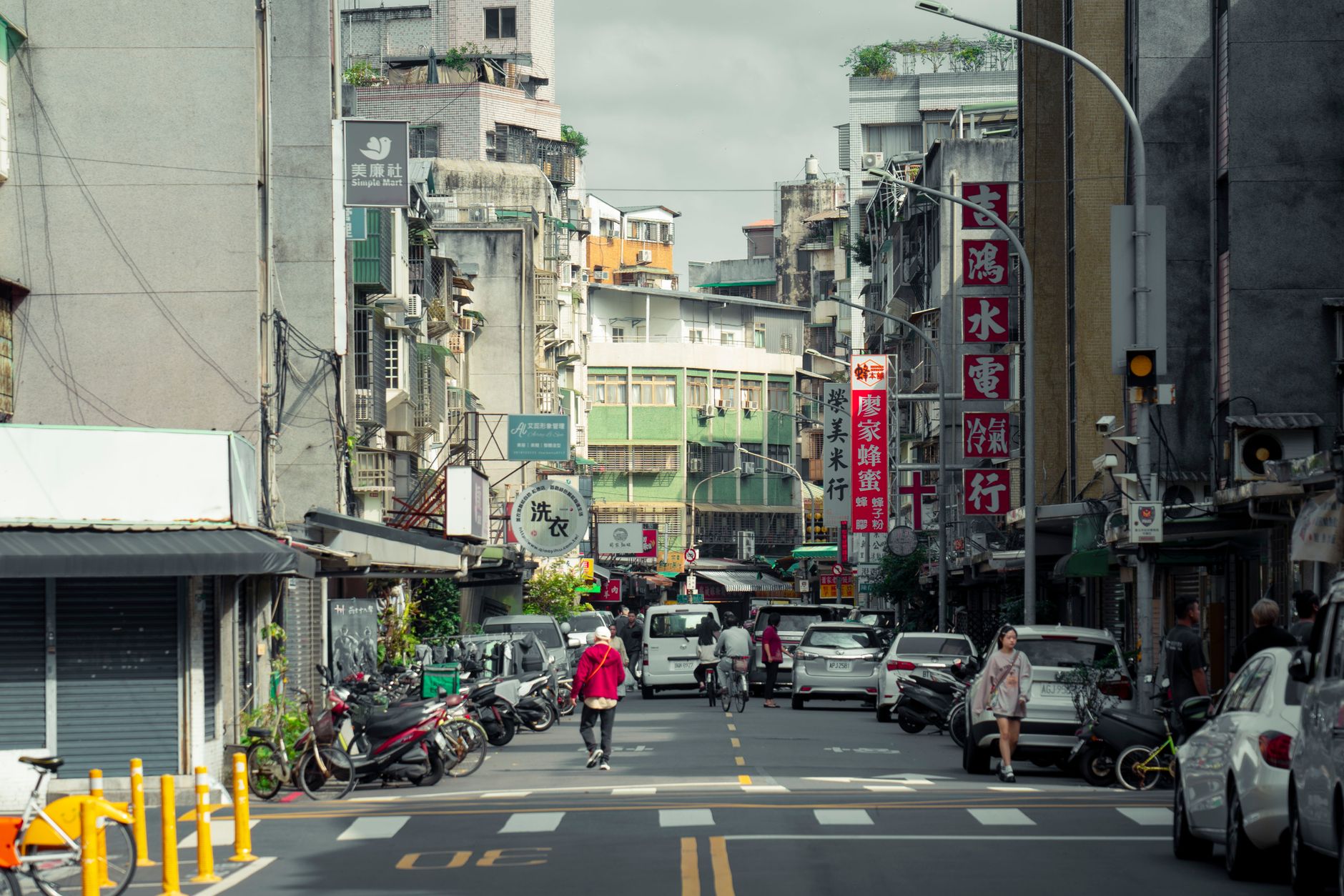 A vibrant city street scene in Taipei, Taiwan, with traditional shops and local traffic.