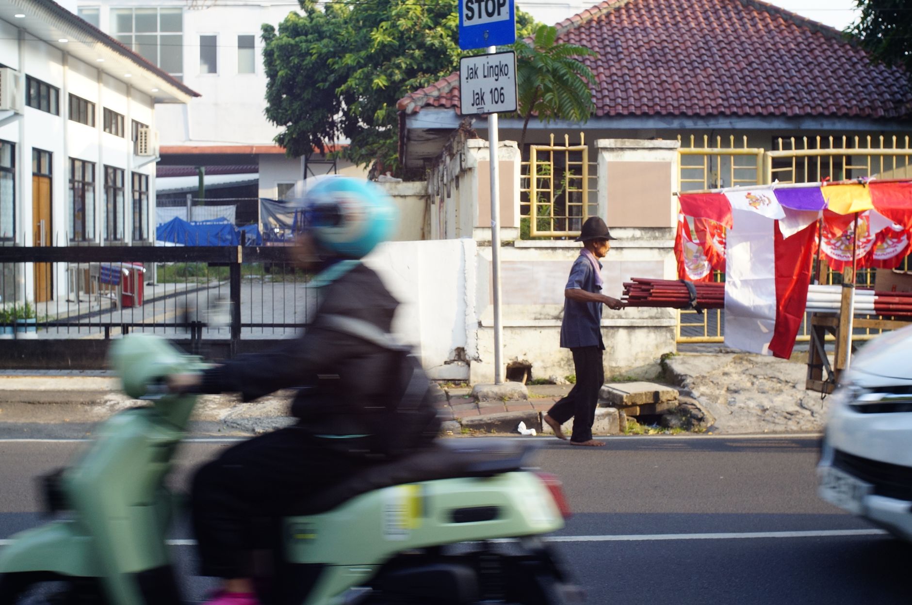 A busy urban street with a motorbike and vendor, showcasing dynamic city life.