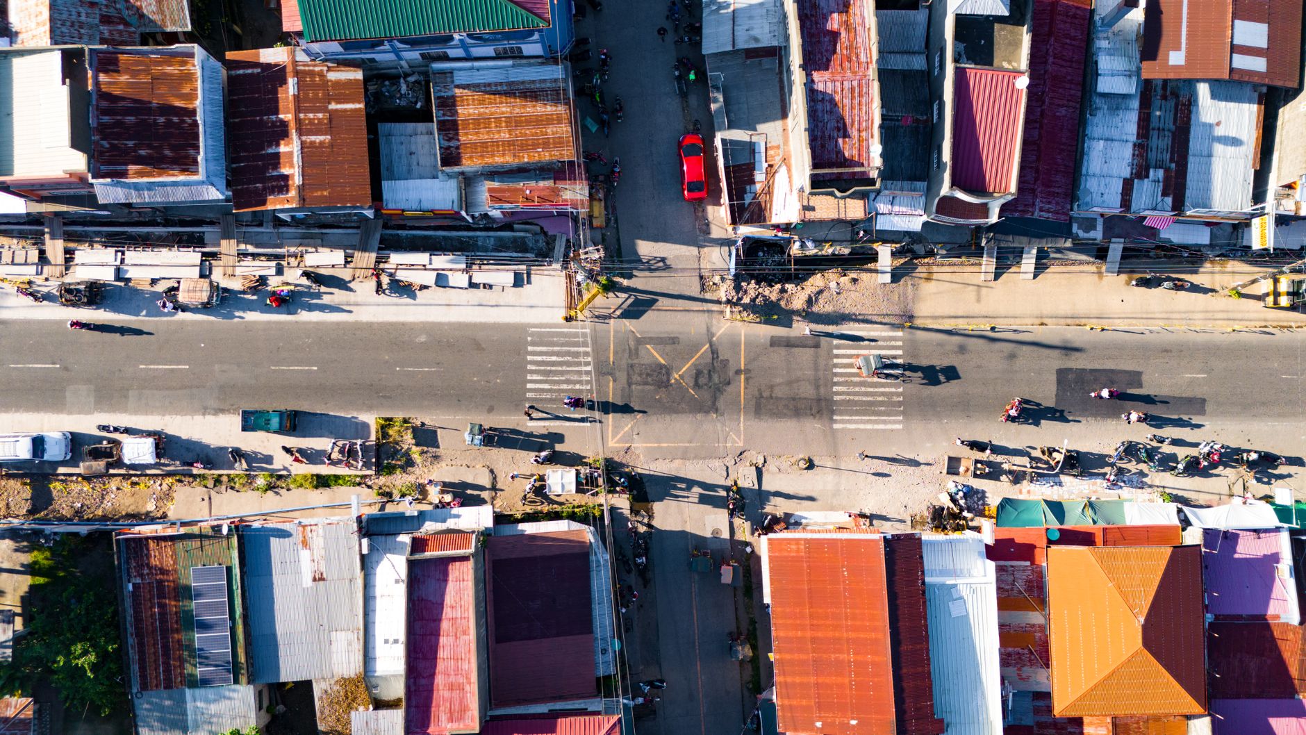 Aerial shot of an urban street intersection in Bacong, Central Visayas, Philippines on a sunny day.