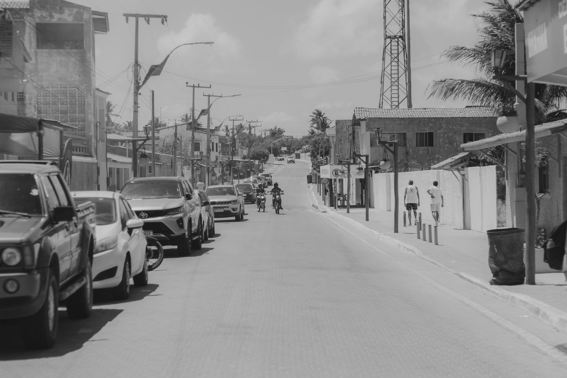Black and white street view with vehicles and pedestrians in Majorlândia, Brazil.