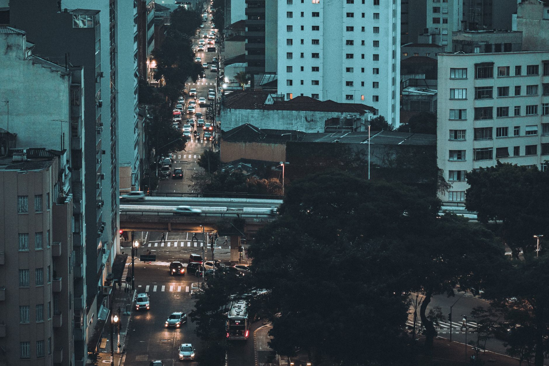 Aerial view of São Paulo city streets with illuminated buildings and traffic at dusk.