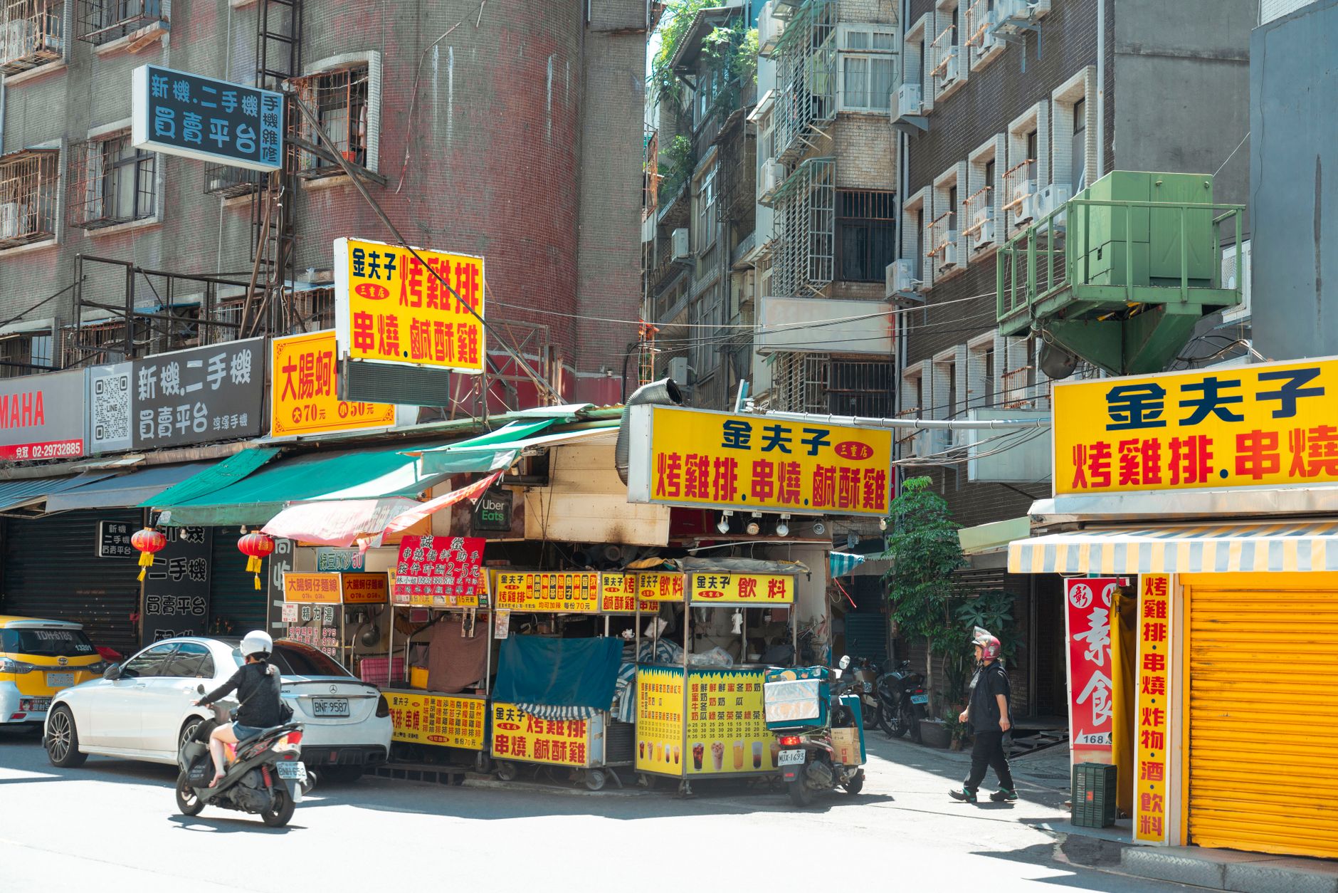 Lively street food scene in Taipei with colorful stalls and bustling city life captured in broad daylight.