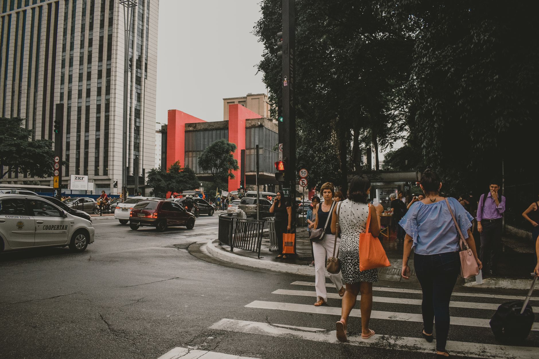 Dynamic urban street scene in Sao Paulo with pedestrians crossing and lively city traffic.
