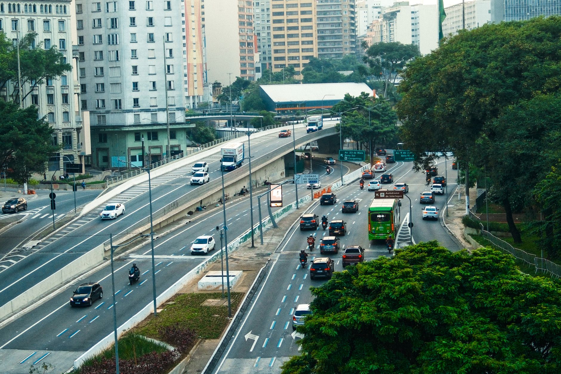 An overhead view showcasing the bustling traffic on a São Paulo highway amid green urban surroundings.
