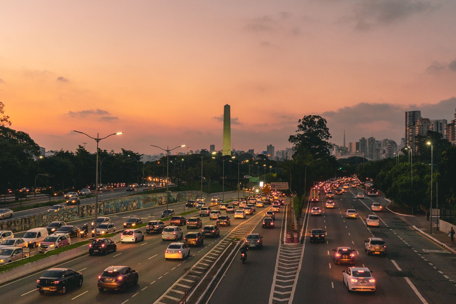 Aerial view of city traffic on expressway at sunset, capturing urban life and cityscape.