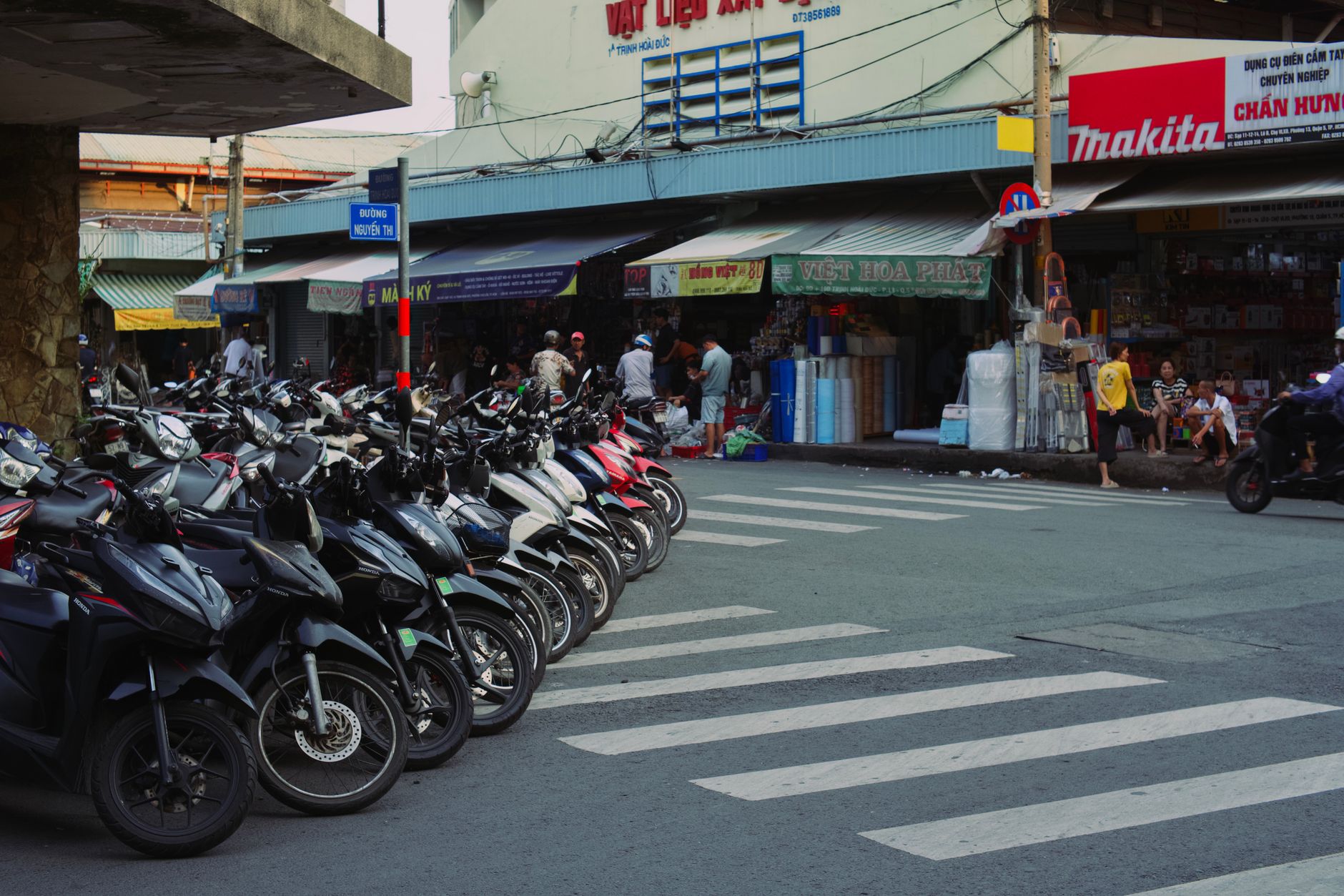 Vibrant street market in Vietnam with lined motorbikes and bustling activity.
