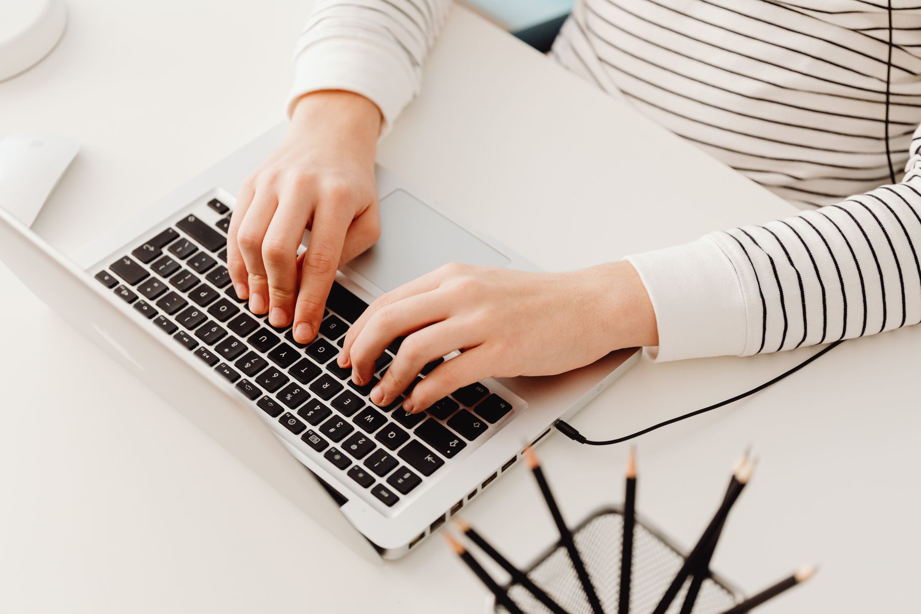 Pessoa digitando em notebook usando software de copywriting com IA