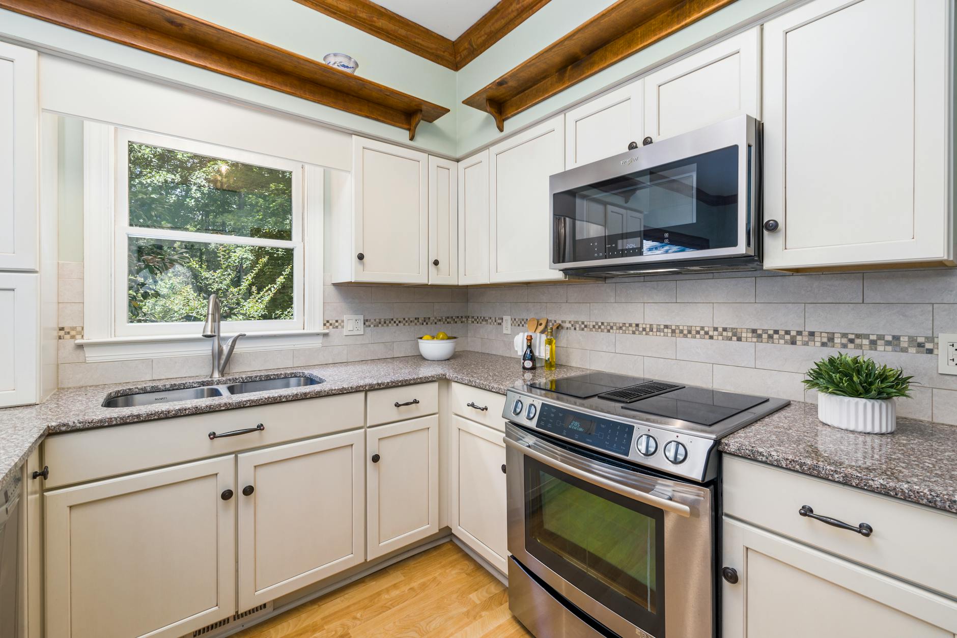Bright kitchen interior with granite countertops and stainless steel appliances.